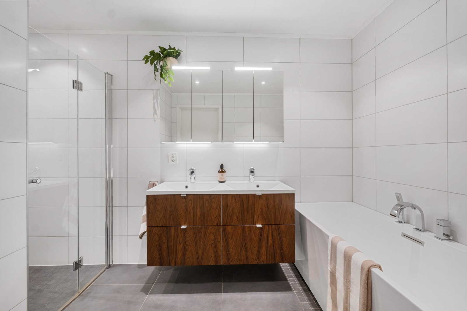 Baderomsinnredningen med folierte fronter består av dobbel servant med skuffer under og overskap med speilskap. Galleribilde