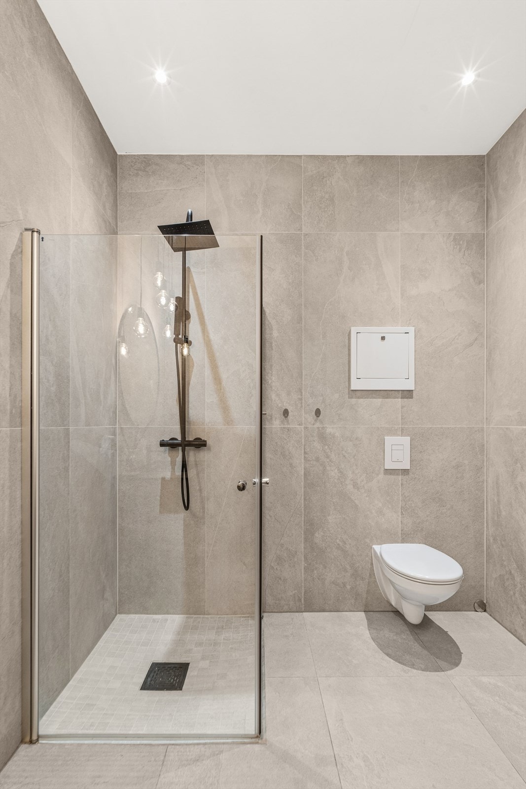 Rommet er innredet med servantskap, wc og dusjnsisje med glassdører Galleribilde