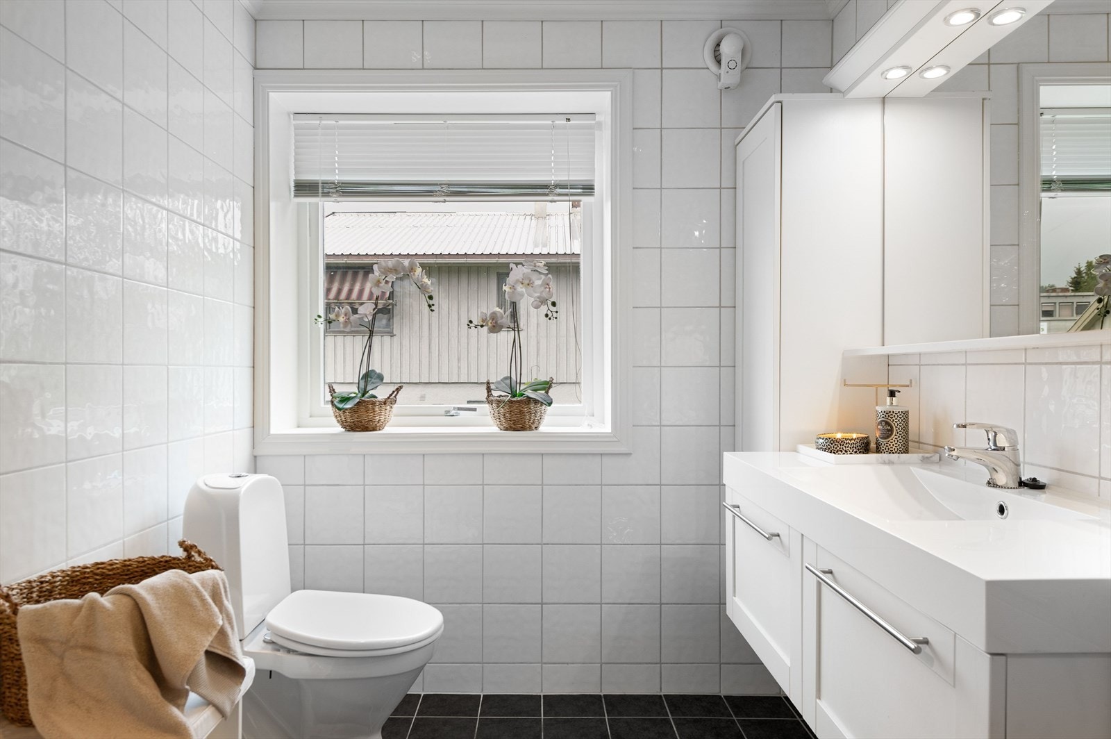 Baderomsinnredning med vask i porselen med etgrepsarmatur, gulvmontert toalett og dusjhjørnet. Galleribilde