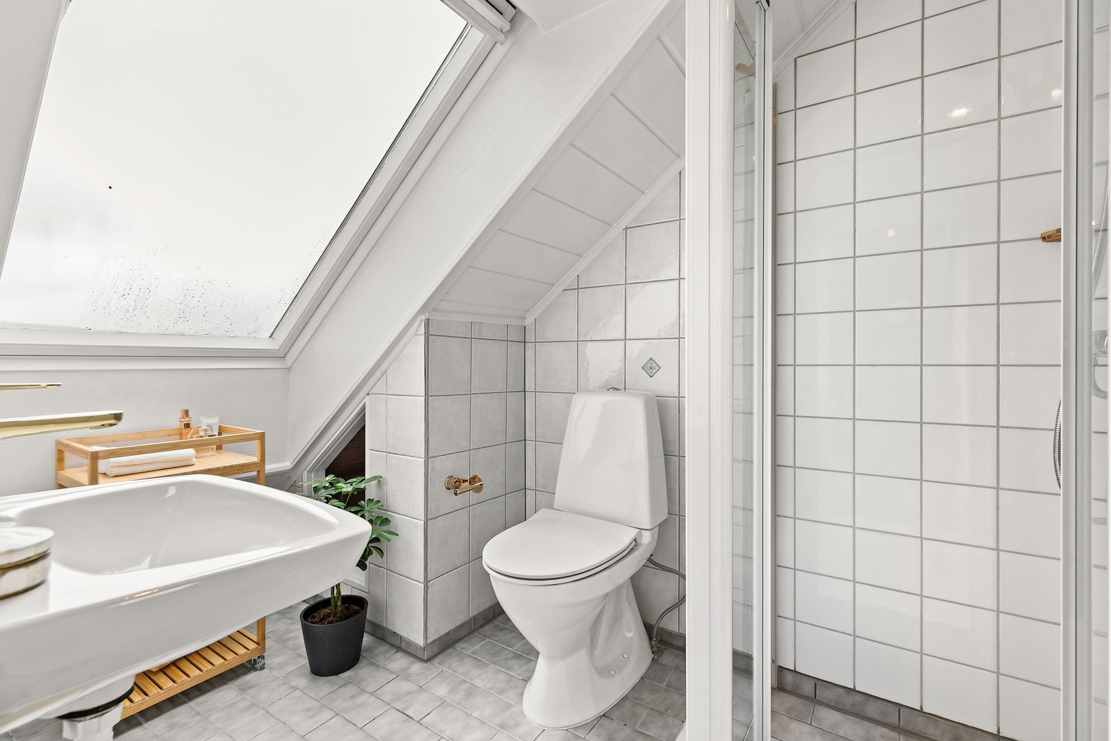 Lyst og praktisk bad i loftetasjen med dusj, servant og toalett. Galleribilde