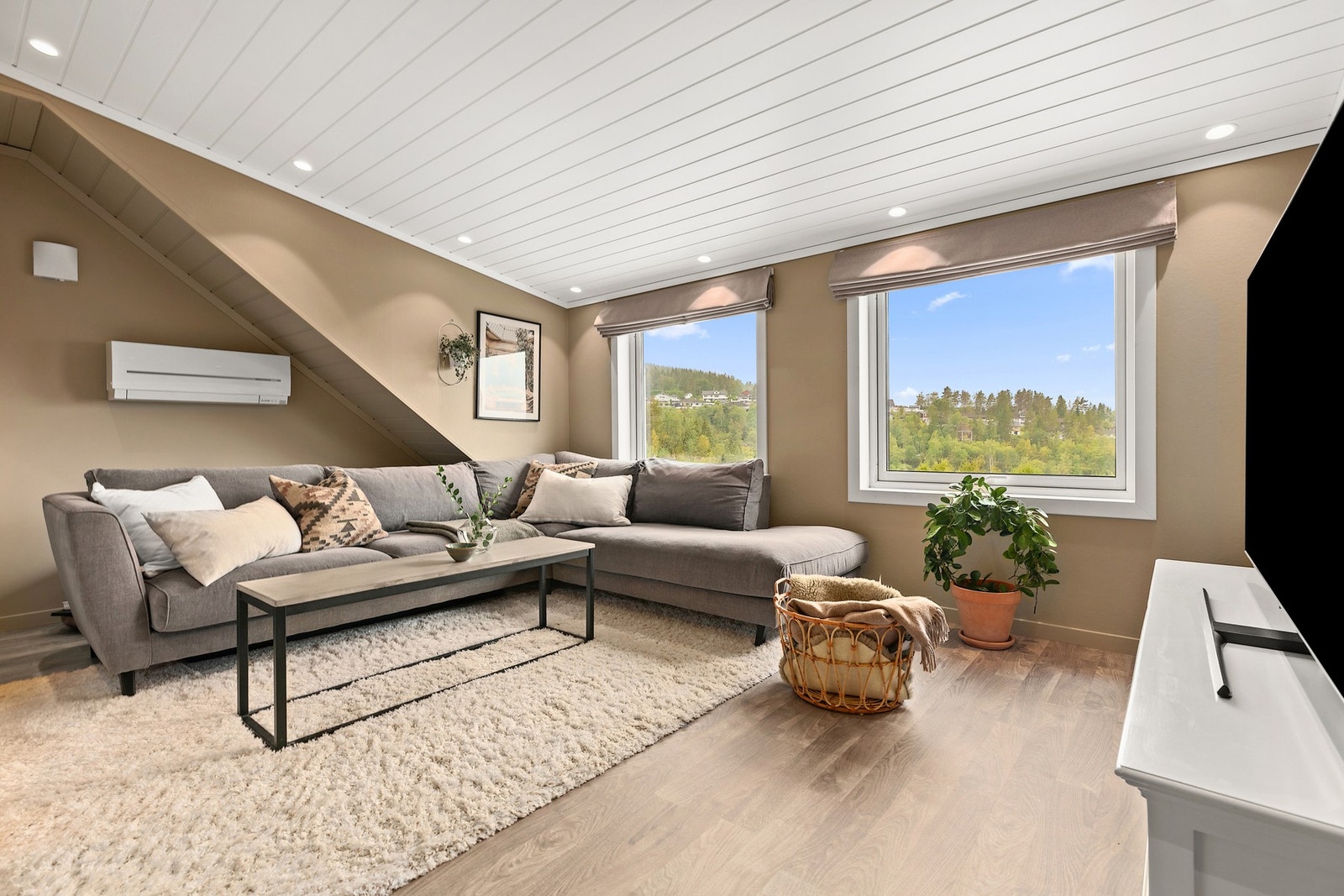 Lys og luftig loftsstue - et fleksibelt oppholdsrom med plass til både sofa og lek. Galleribilde