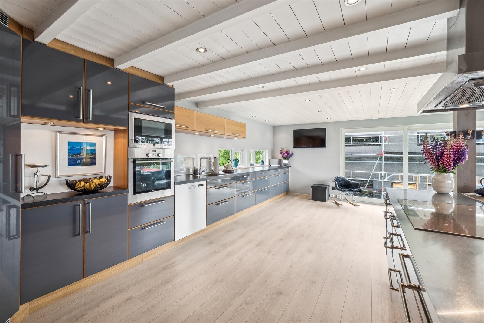 Pent kjøkken med glatte fronter og laminat benkeplate med oppvaskkum, samt downlights i himling. Galleribilde