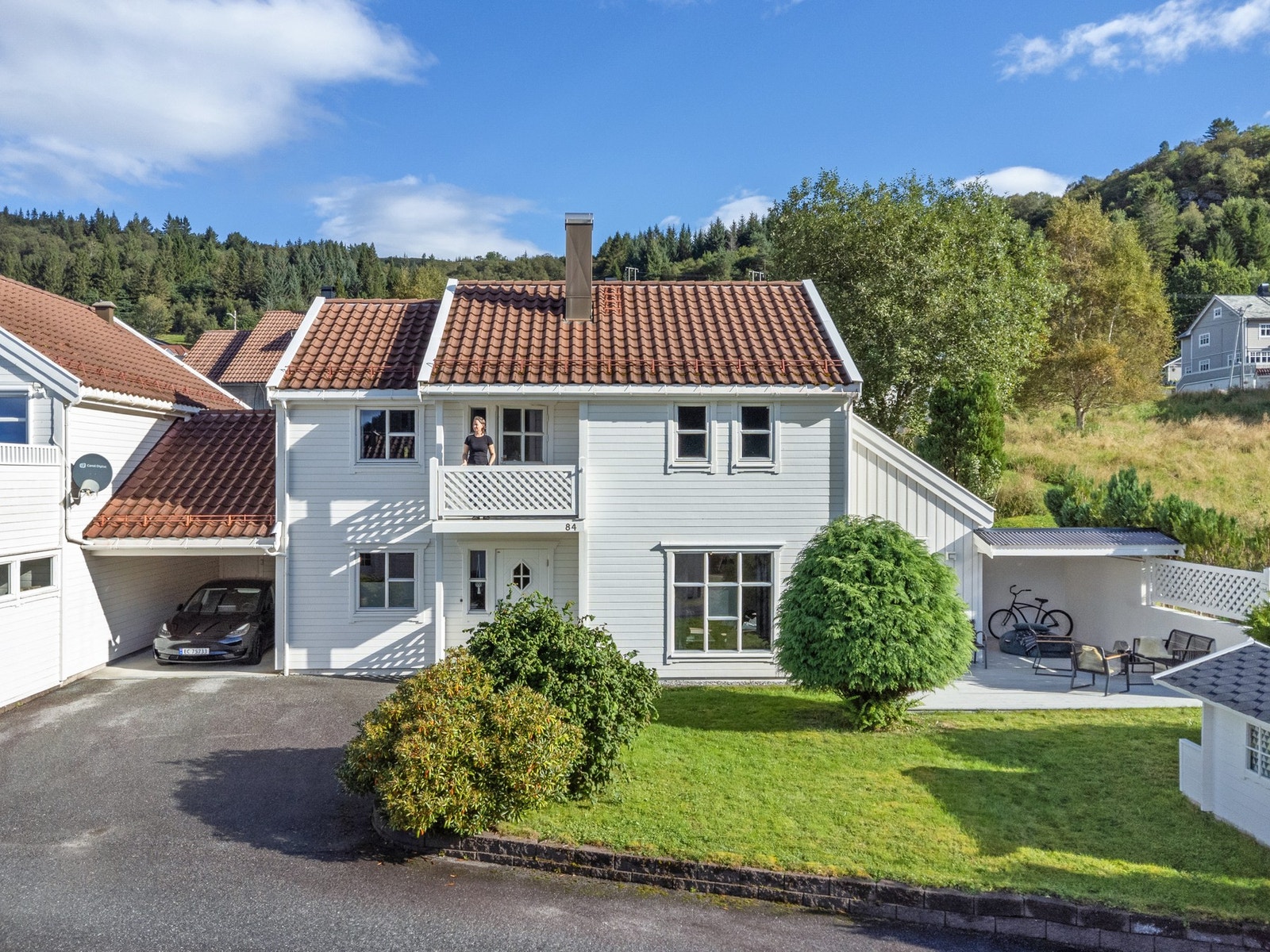 Carport og asfaltert adkomst, bod i bakkant av carporten og en herlig balkong i 2. etg. Legg også merke til lekestua i hagen. Galleribilde