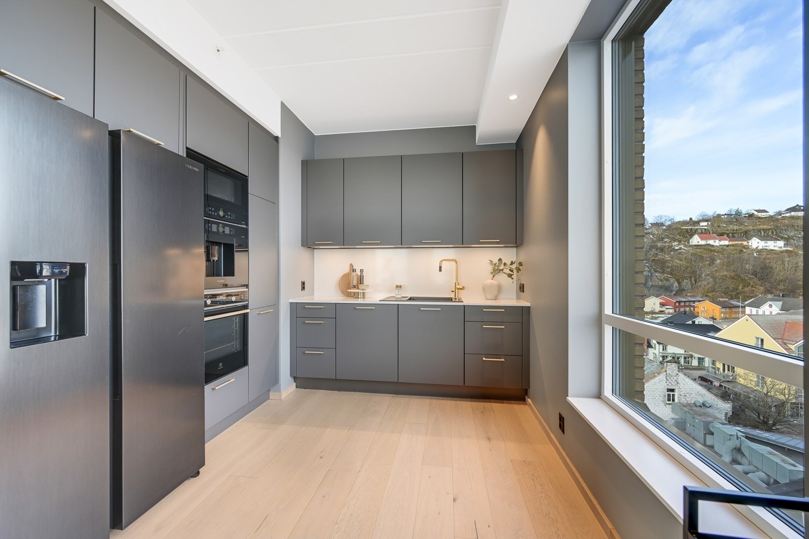 Kjøkkenet er plassert i en "privat" sone av rommet. Det er montert integrerte hvitevarer av høy kvalitet som stekeovn med dampfunksjon, mikrobølgeovn, kaffemaskin og oppvaskmaskin. Galleribilde