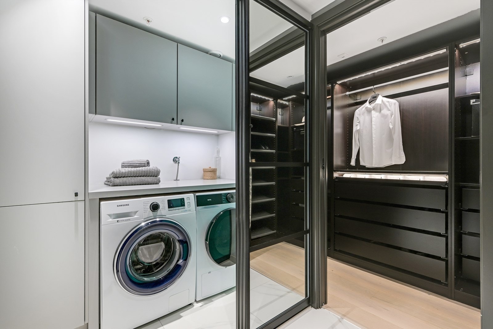 Vaskerommet er pent plassert bak en stor skyvedør, med samme fliser på gulvet som i mellomgangen. Rommet er praktisk og komplett innredet med opplegg for vaskemaskin, innredning med skapplass på vegg, plass for tørketrommel og benkeplass. Galleribilde