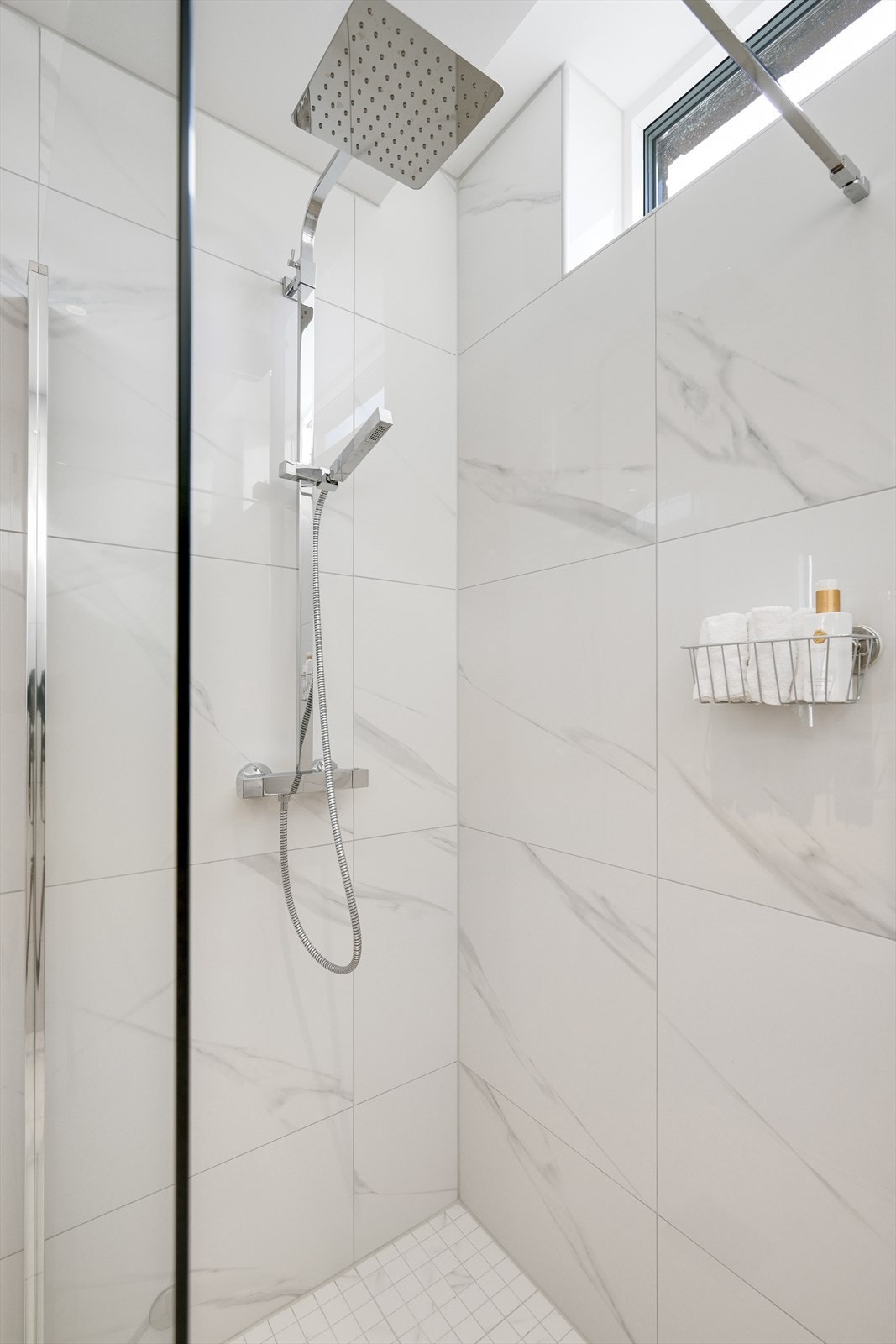 Badet sin dusjsone er sømløst utført med rainshower og glassvegg. Galleribilde