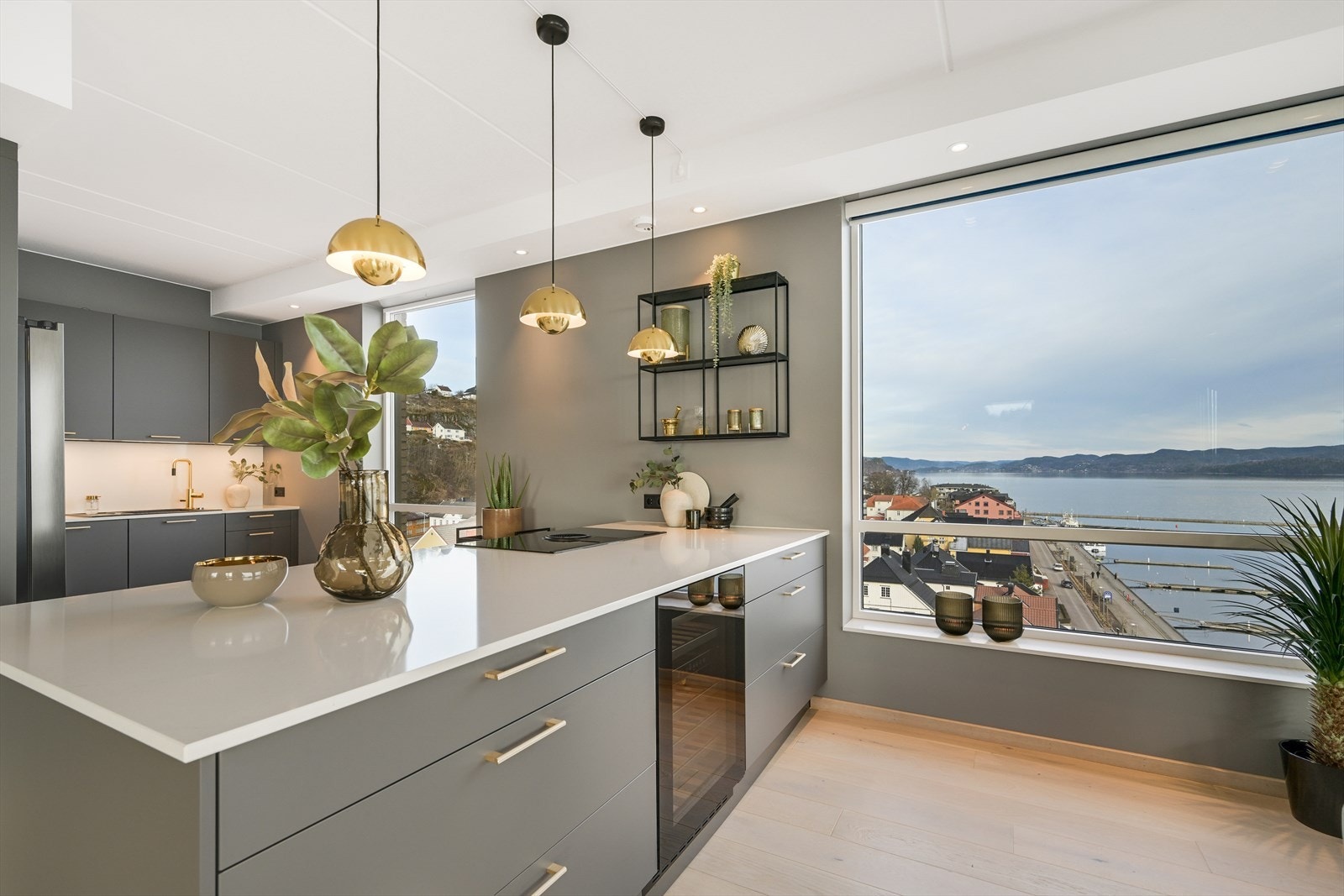 Det flotte kjøkkenet har åpen løsning mot stuen og spisestuen, med moderne og påkostet kjøkkeninnredning med tilhørende kjøkkenøy i grå utførelse. Galleribilde