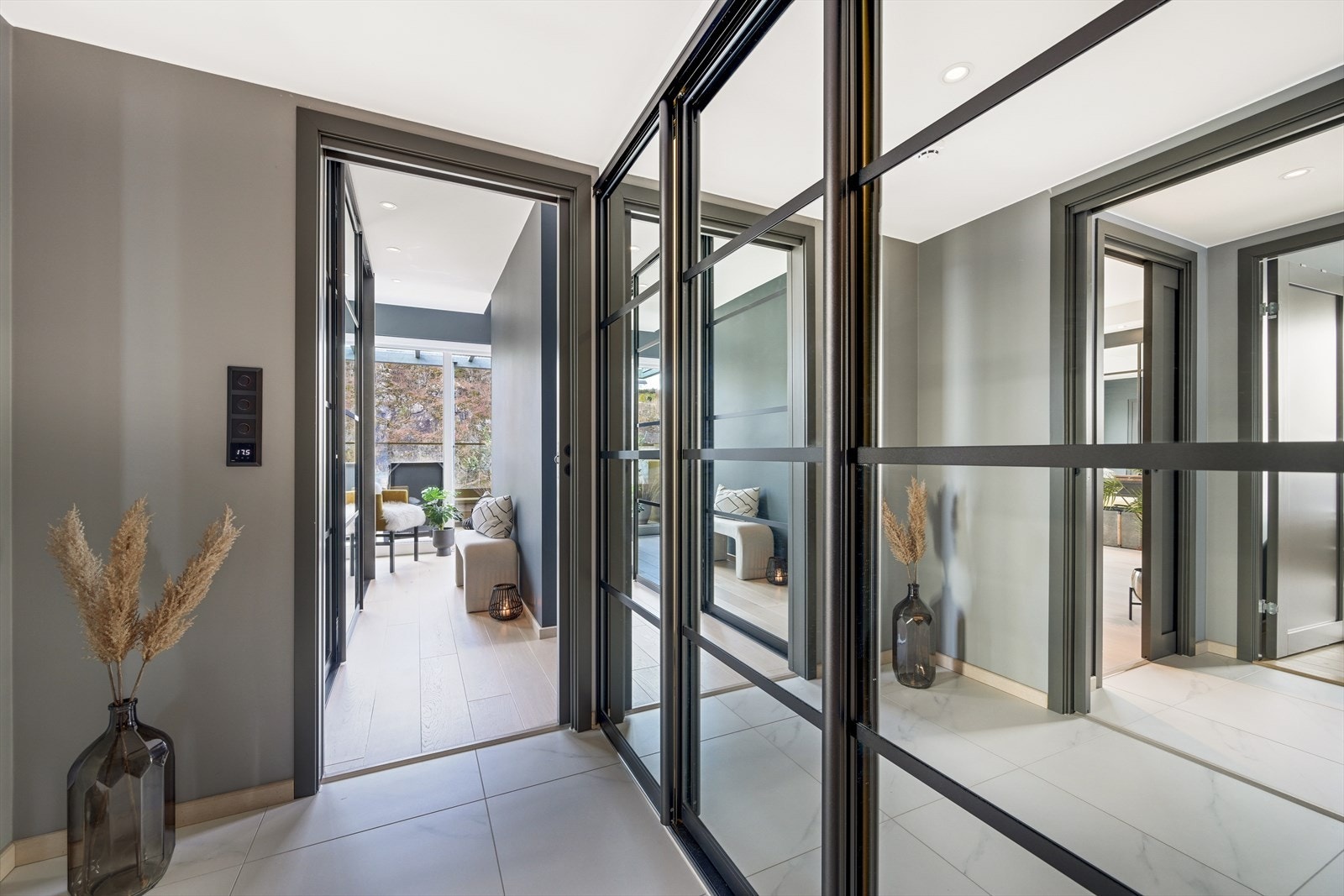 Fra hallen er det inngang til en egen mellomgang som er pent gjennomført med 60 x 60 cm fliser på gulvet i lys marmorutførelse, med behagelig varme. Fra denne mellomgangen er det videre inngang til egen vaskeromsdel, Walk-in garderobe og hovedsoverom. Galleribilde