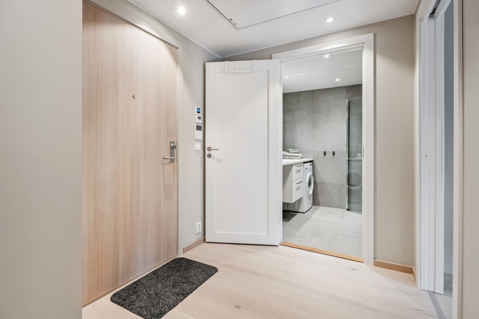 Romslig gang med garderobeskap. Ventilasjonstyring og ringeklokke med video på vegg. Galleribilde