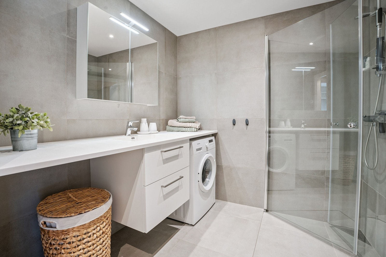 Flislagt bad med varme i gulv, og god plass til vaskemaskin. Dusjhjørnet med dører som felles inn mot dusj. Galleribilde