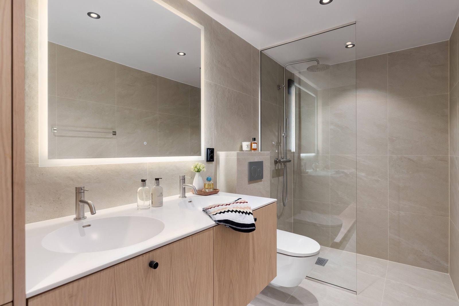 Det flislagte badet ble også oppgradert i 2024 og er moderne, romslig og gjennomført. Gulvvarme og downlights sørger for komfort og stemning. Galleribilde