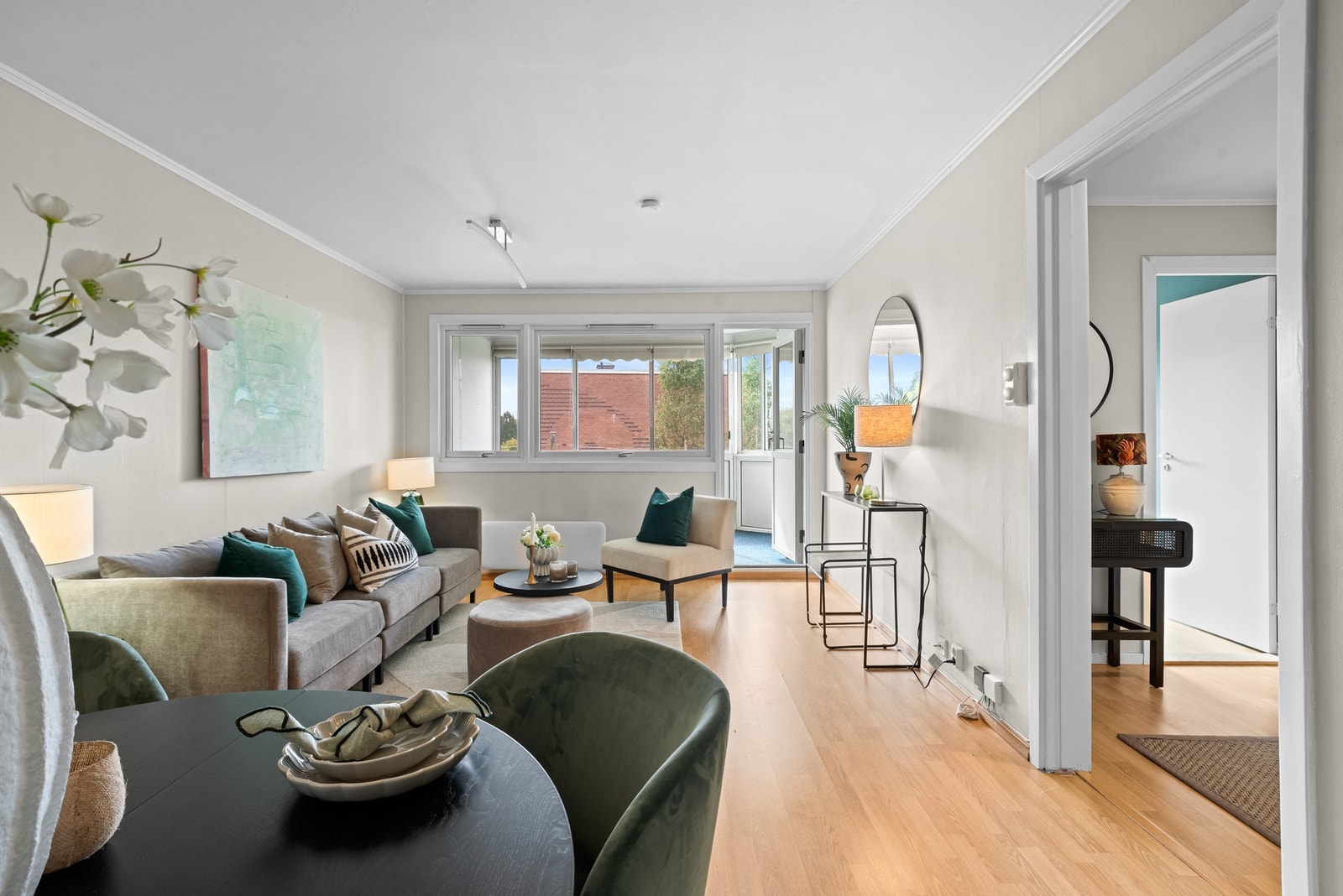 Lys fra vinduene sørger for at rommet føles lyst og luftig, noe som er praktisk både for lesing og sosiale sammenkomster. Galleribilde