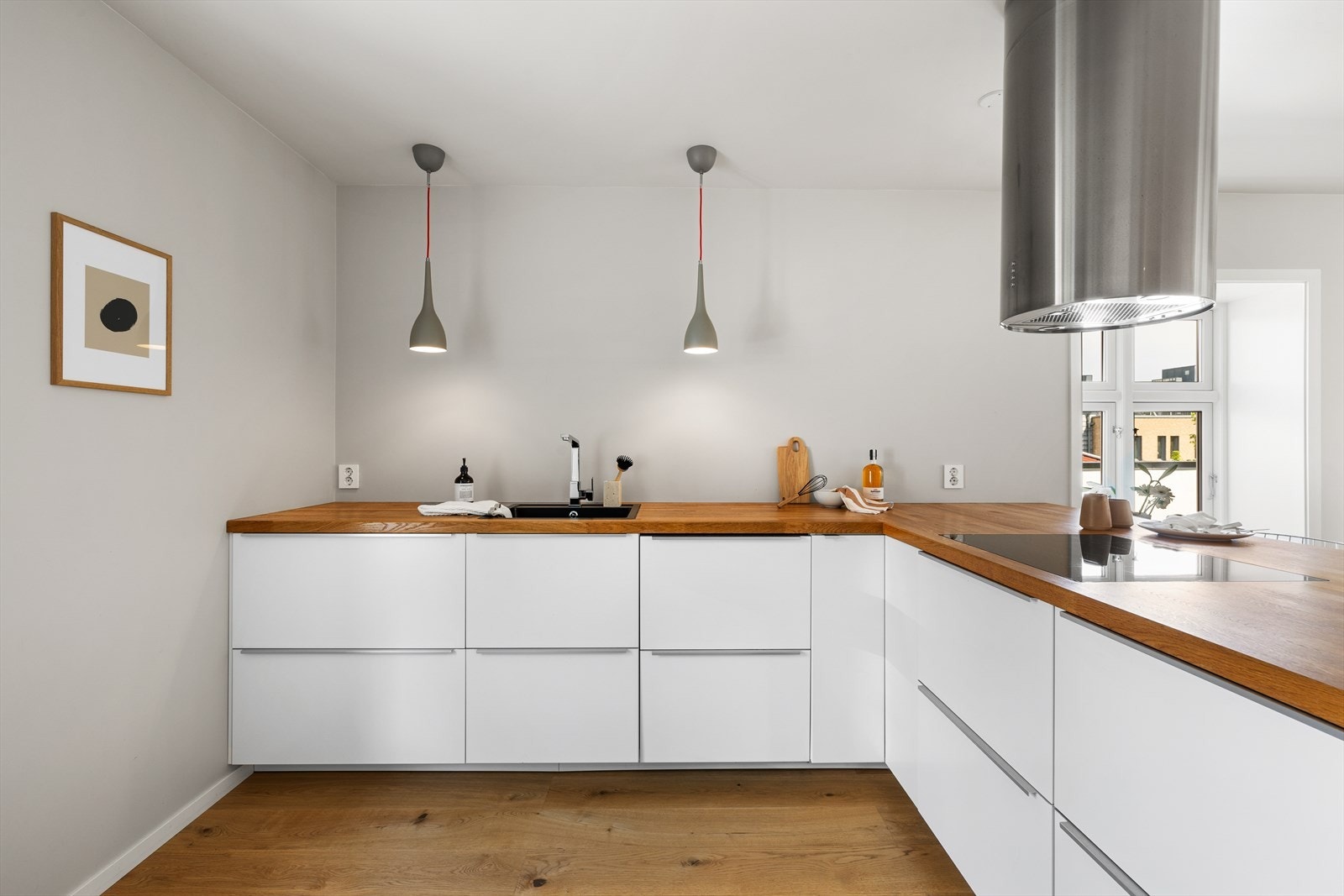 Kjøkkenet er stilfullt innredet med glatte fronter og en heltre benkeplate. Galleribilde