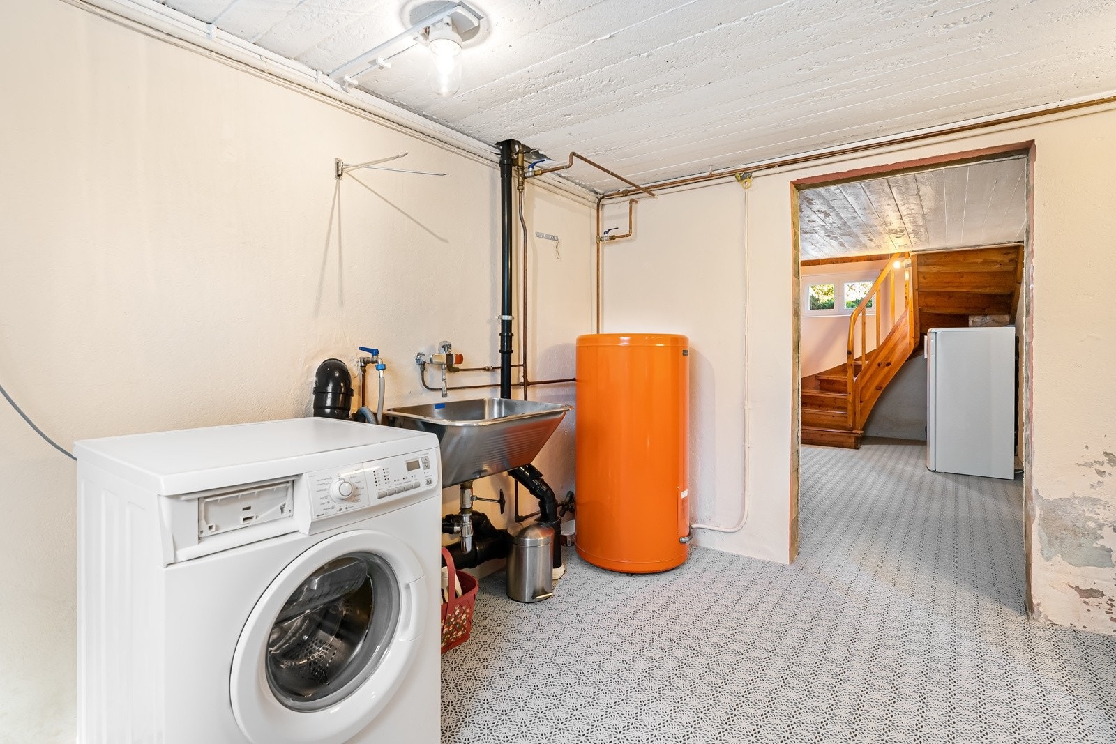 Praktisk vaskerom i boligens kjelleretasje. Skyllekum i rustfritt stål og opplegg for vaskemaskin og tørketrommel. Vaskerommet er gitt TG2, foruten himling og sanitærinstallasoner som er gitt TG1. Galleribilde