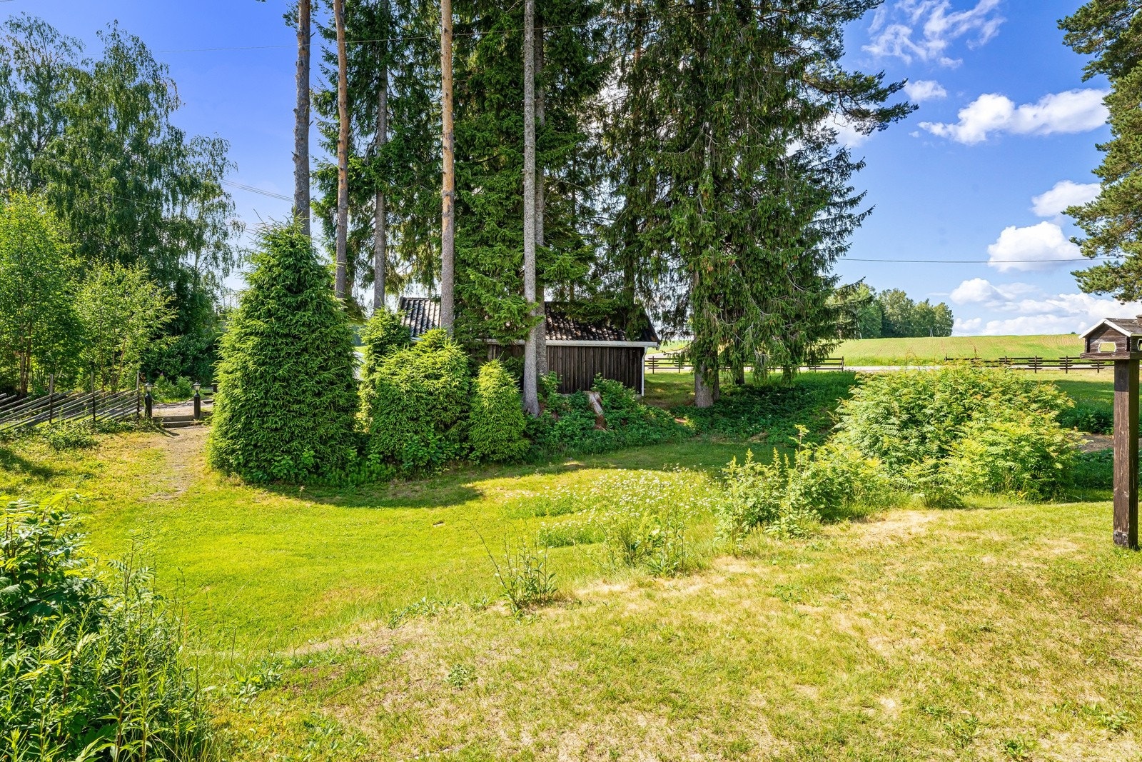 Eiendom sett fra hovedhus mot garasje og bussholdeplass Galleribilde