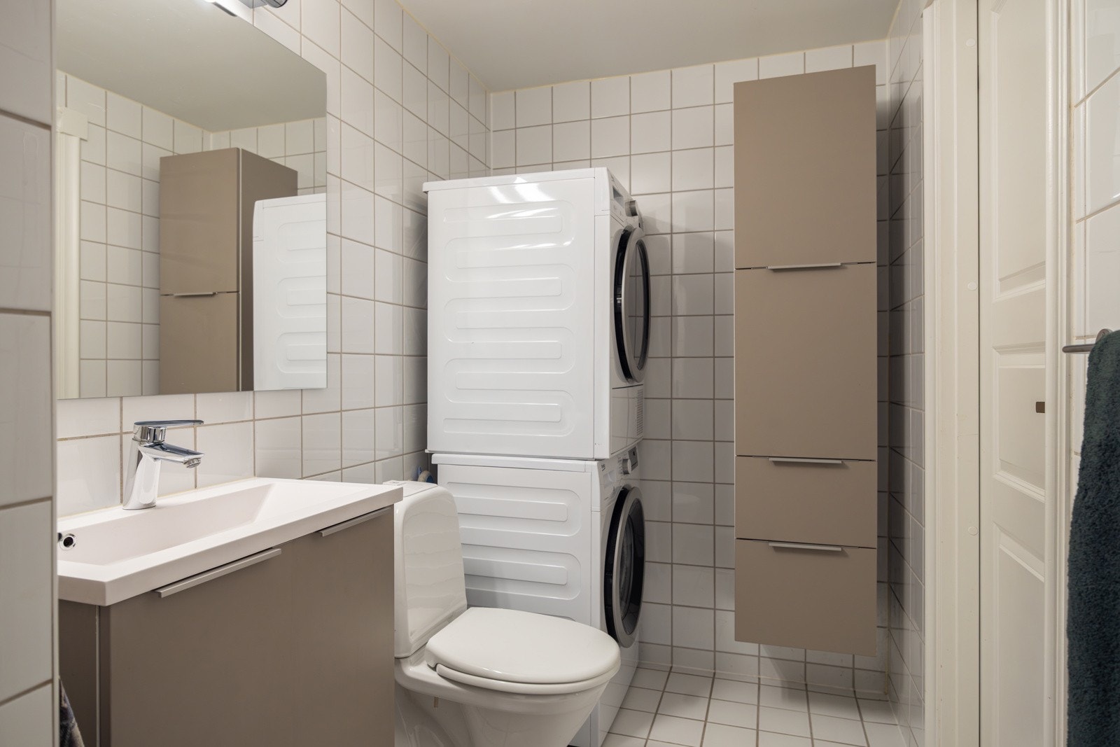 Videre er det opplegg for både vaskemaskin og tørketrommel, samt oppbevaring i vegghengt skap. Galleribilde