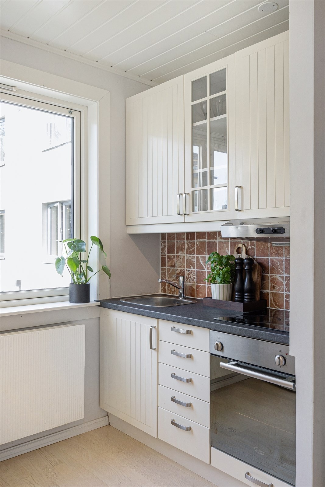 Innredningen fra IKEA har laminert benkeplate, fliser mellom overskapene og lyslist som gir godt arbeidslys. Galleribilde