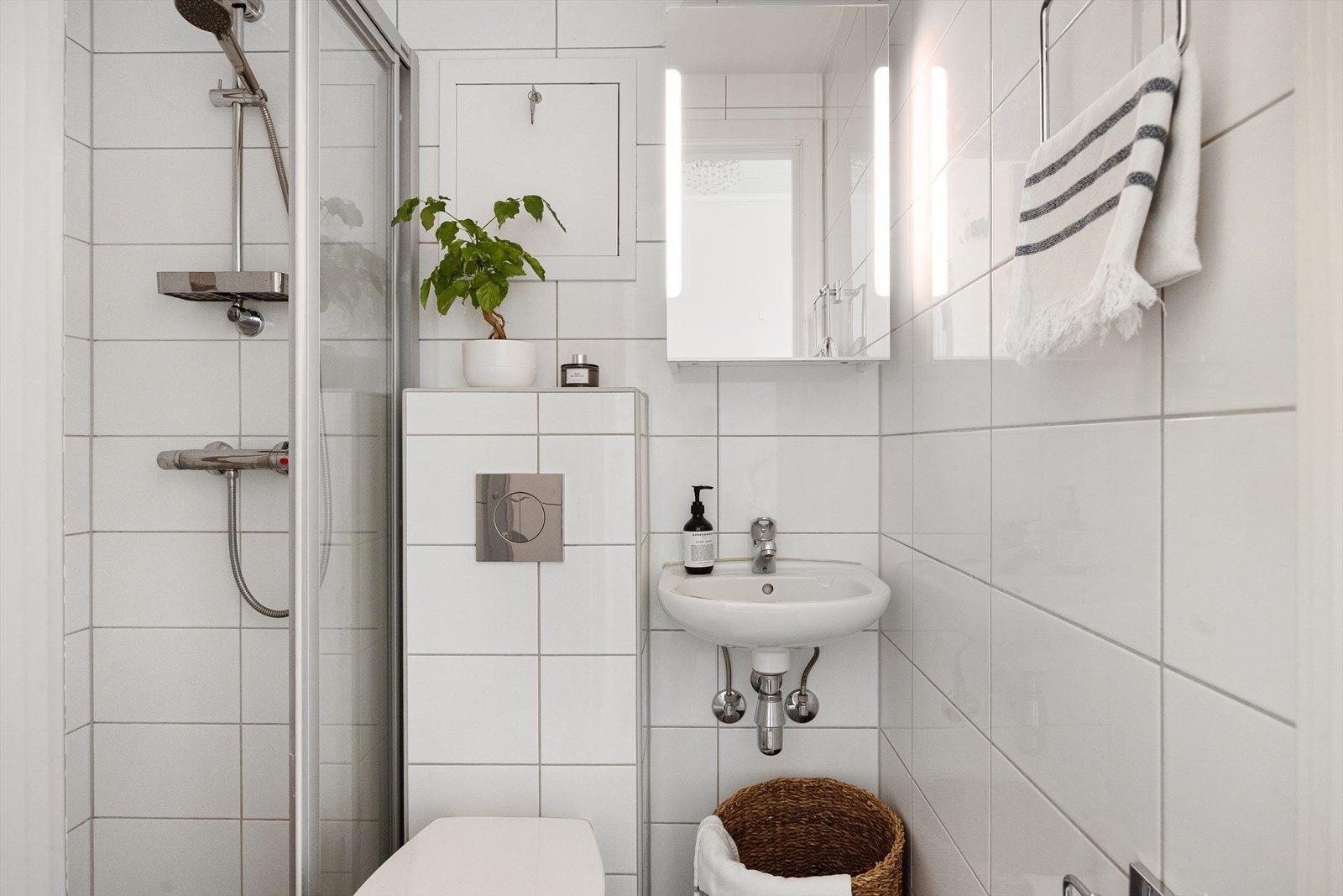 Badet består av veggmontert WC, dusjplass med dusjvegg og servant med ettgreps blandebatteri i innredning. Galleribilde