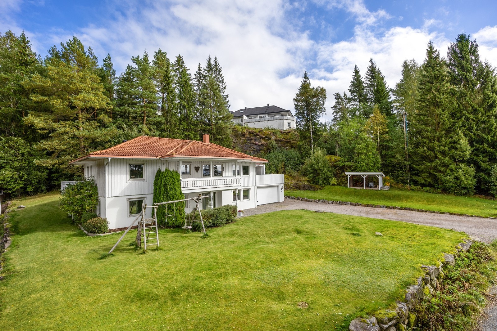 Tomten på 1051,9 kvm er pent opparbeidet med store plenarealer, asfaltert gårdsplass og støttemur i naturstein. Galleribilde