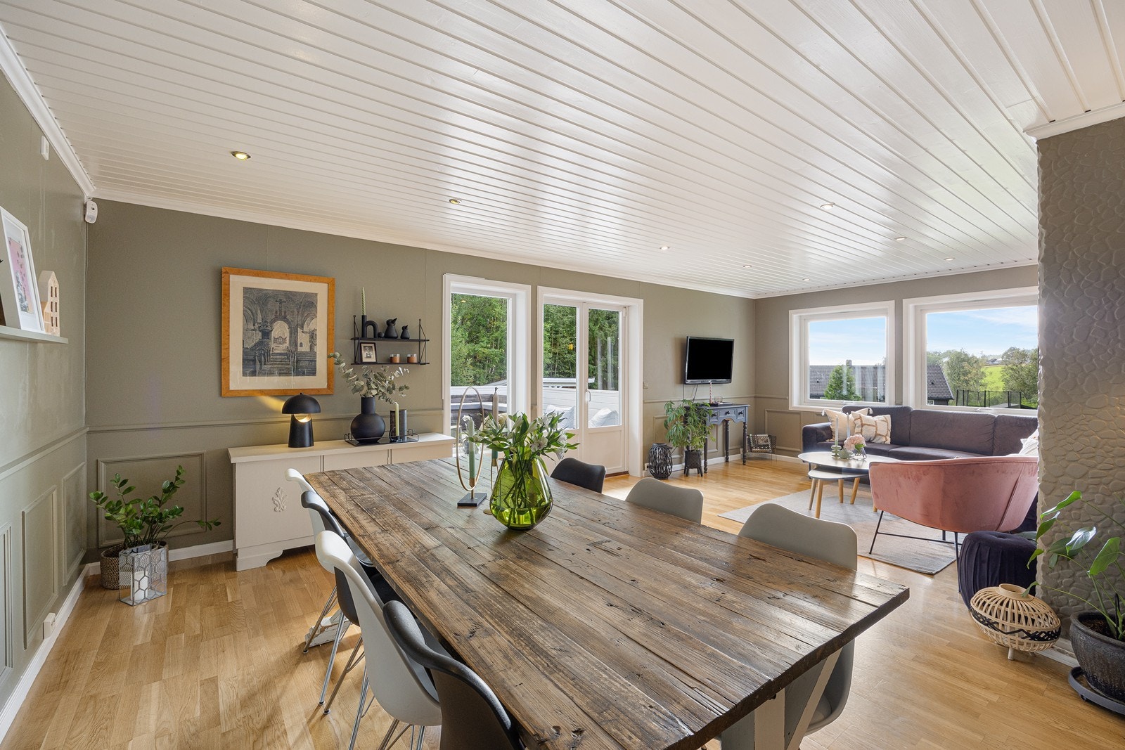 Dagslyset strømmer inn til stuen via store vinduer i tre himmelretninger. Galleribilde