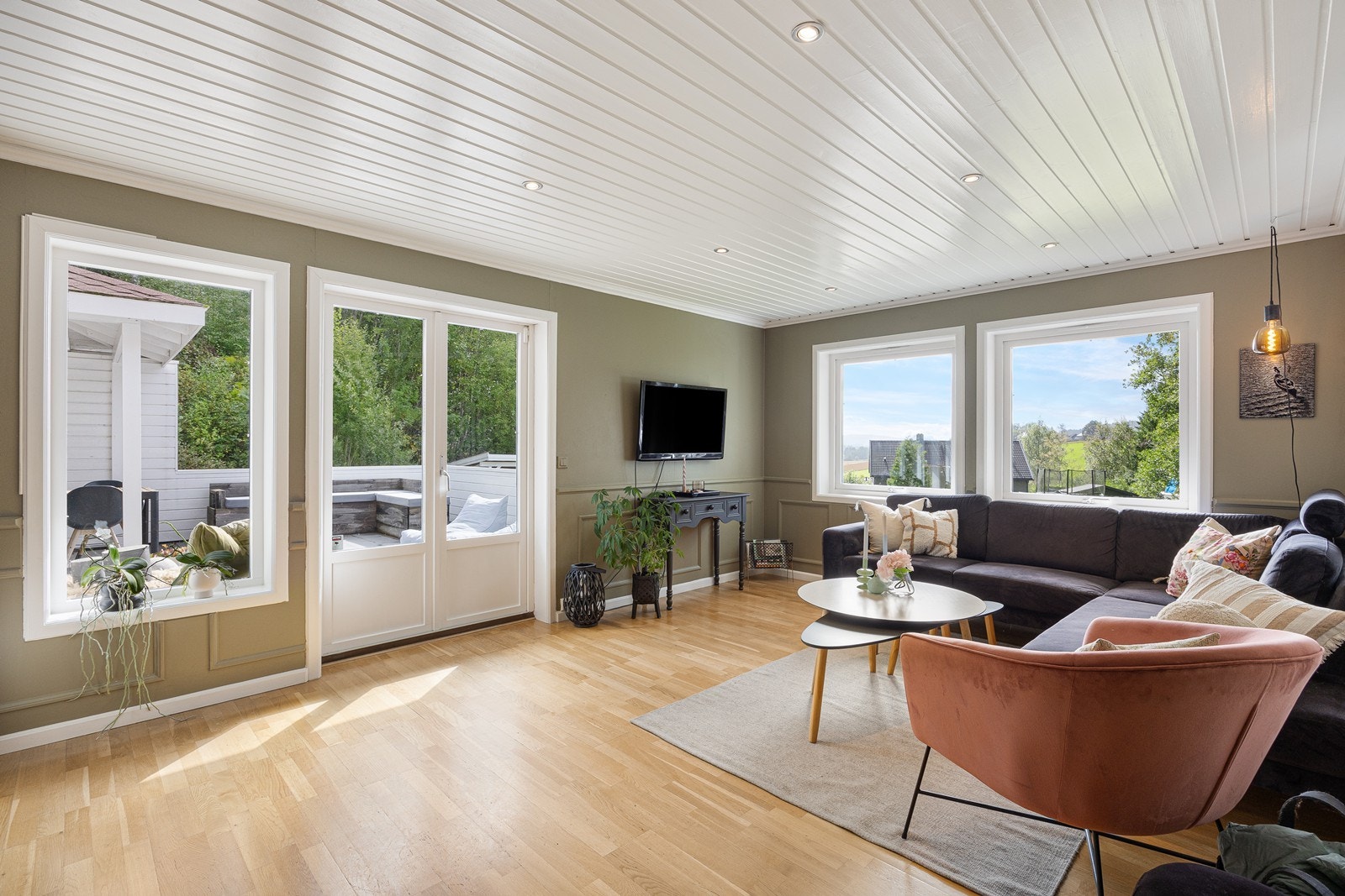 Veggene i stuen er malt i en delikat, grågrønn fargetone som står godt til parkettgulvet. Galleribilde