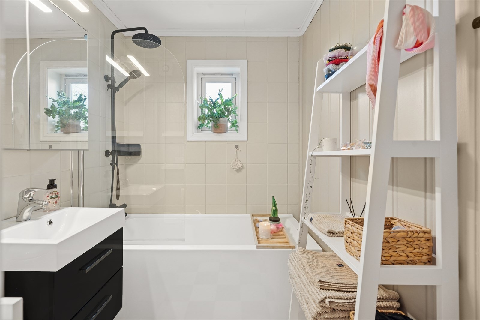 Badet er ustyrt med badekar, servant med speil og toalett Galleribilde