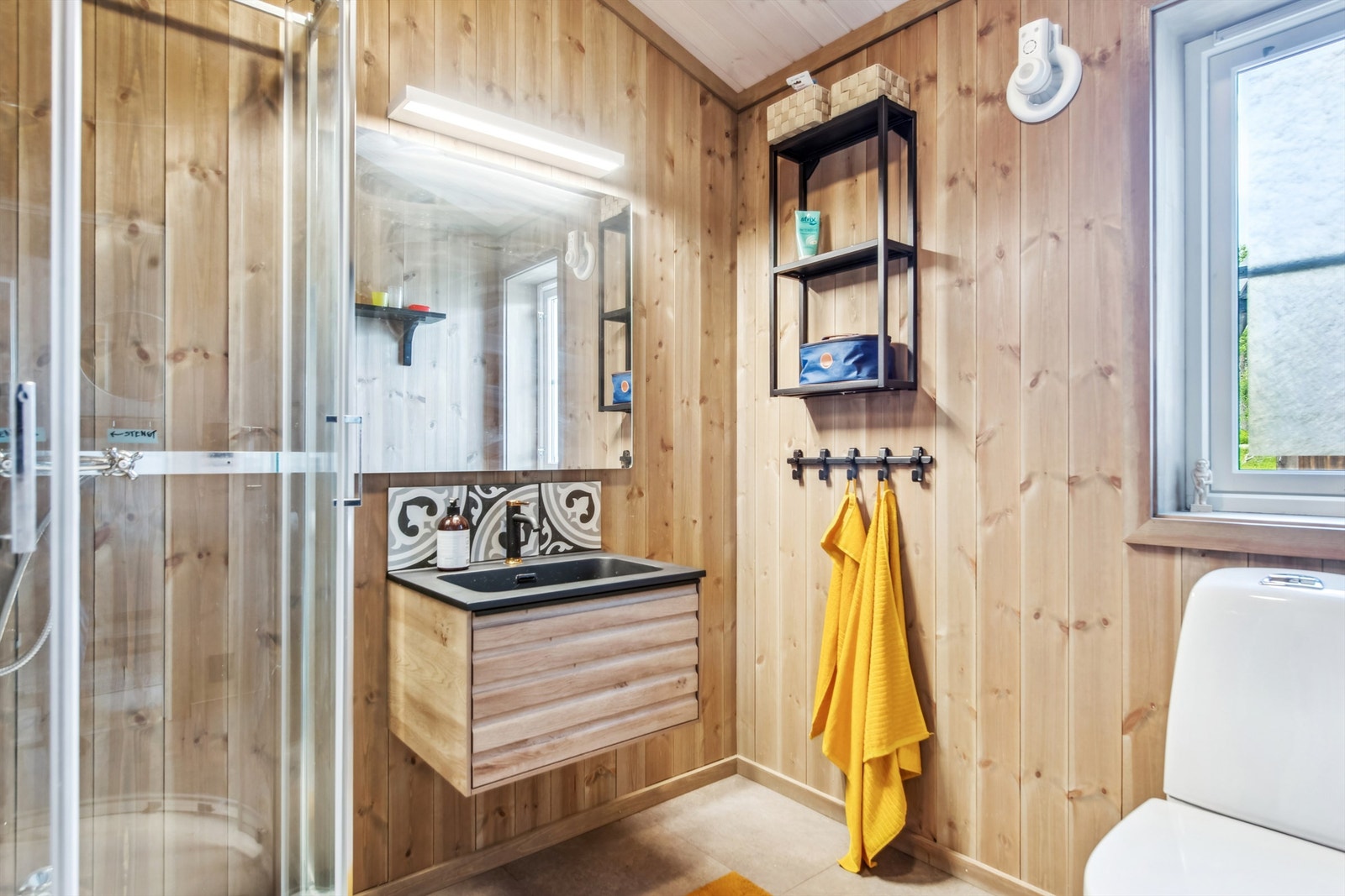 Pent bad med moderne baderomsinnredning med profilerte fronter, heldekkende servant, ett greps blandebatteri, speil og lyspunkt. Galleribilde