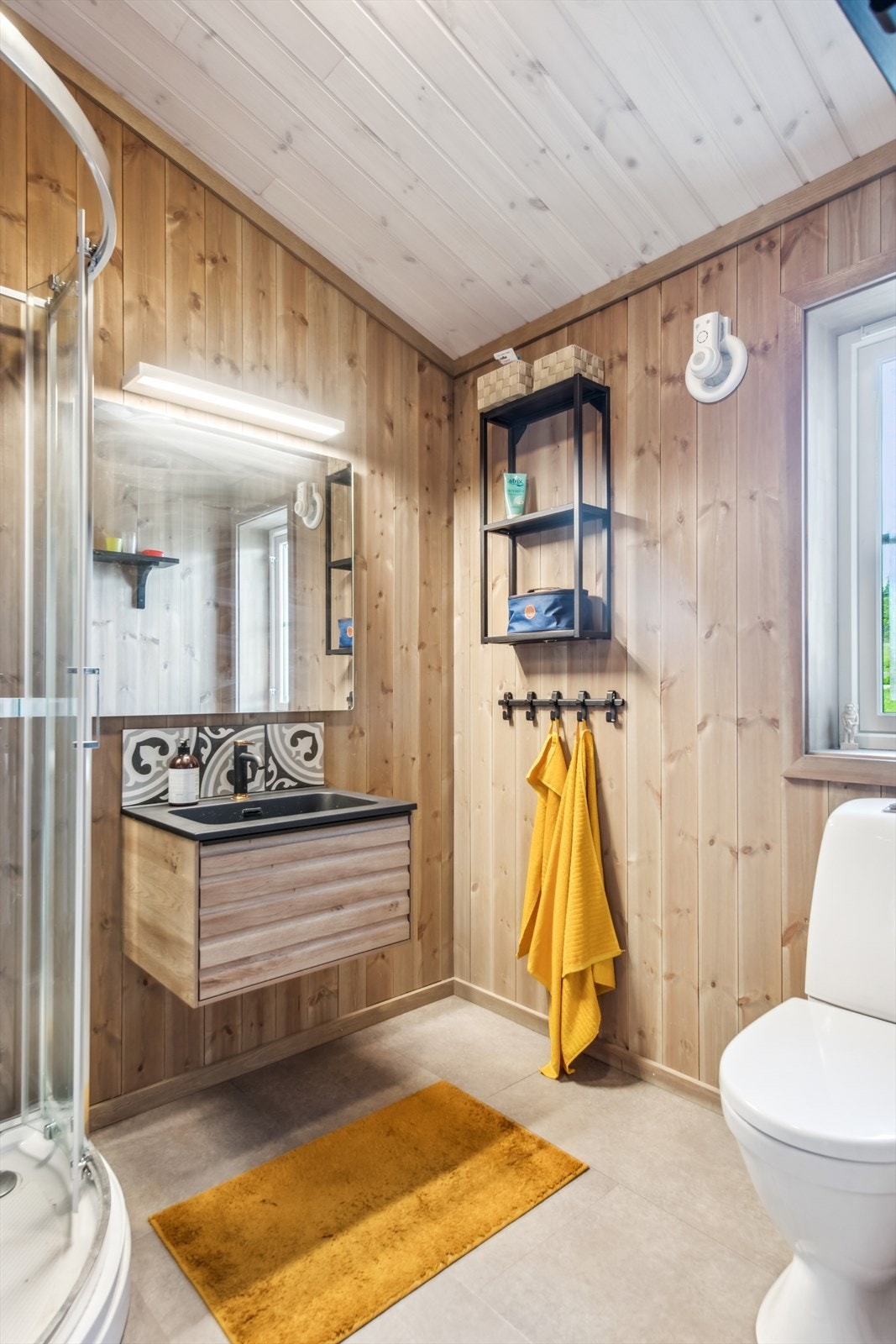 Dusjkabinett med integrert dusjbatteri og gulvmontert toalett. Galleribilde