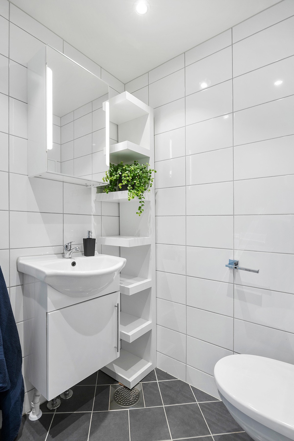 Bad/wc består av inn- utadslående dusjvegger, servant m/underskap, overskap m/speilfronter, hylle og veggklosett. Galleribilde