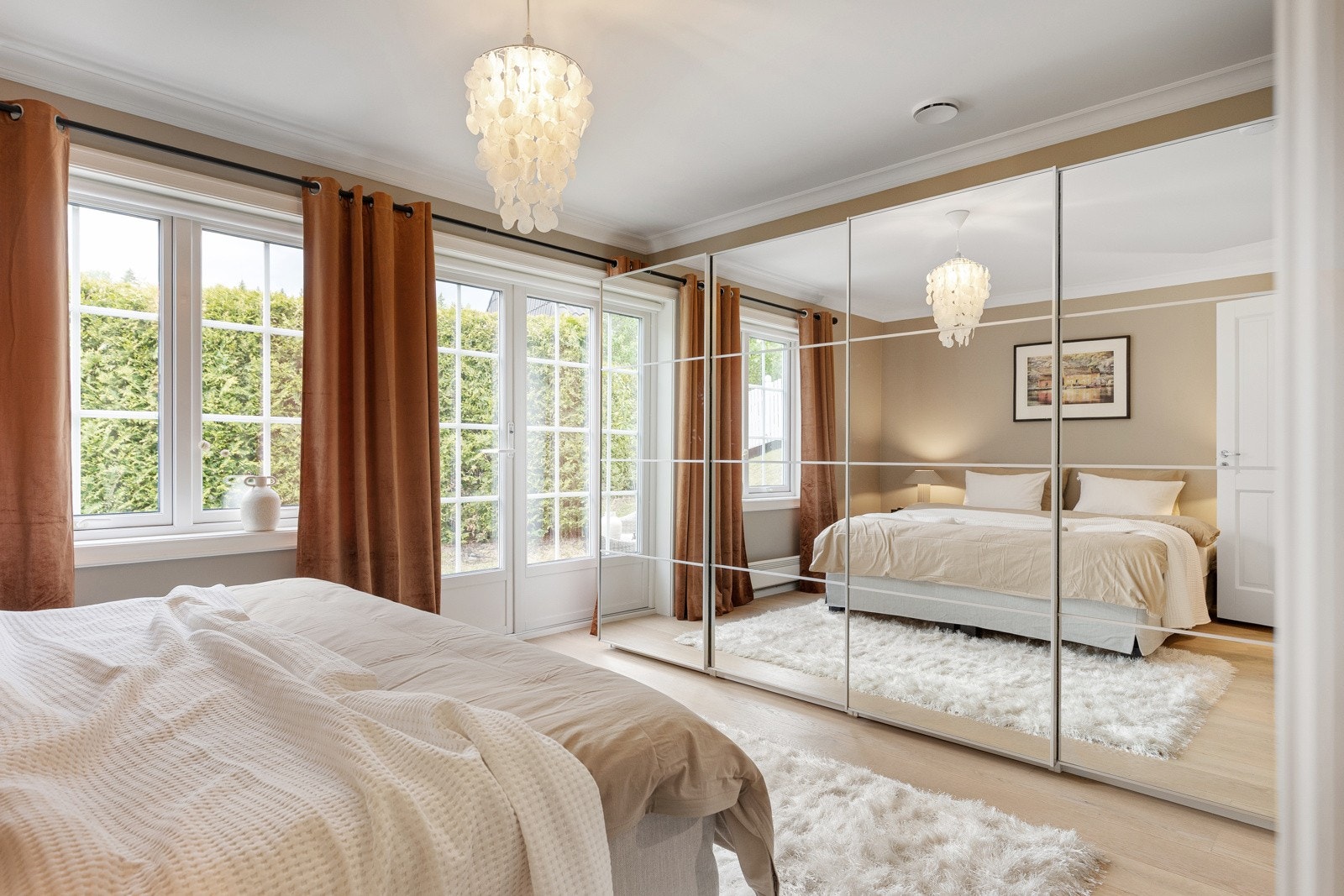 Den ene veggen dekkes av skyvedørsgarderobe i speil Galleribilde