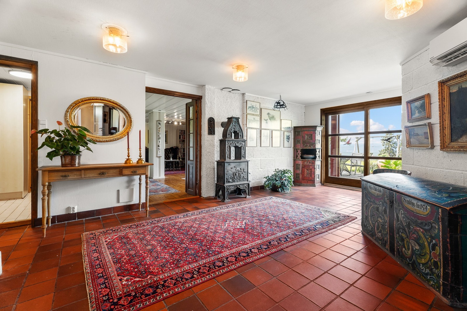 Via trappeløpet tar man seg ned til en stor hall, med utgang til uteplass og hage via skyvedøren. Galleribilde