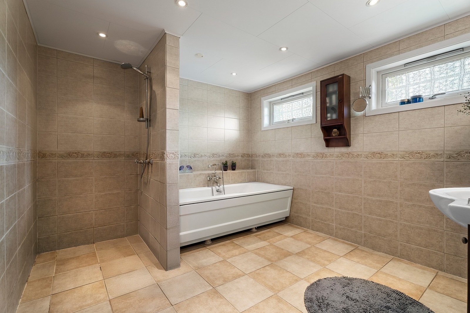 Ved hovedsoverommet er boligens andre bad, med dusjhjørne og badekar. Galleribilde