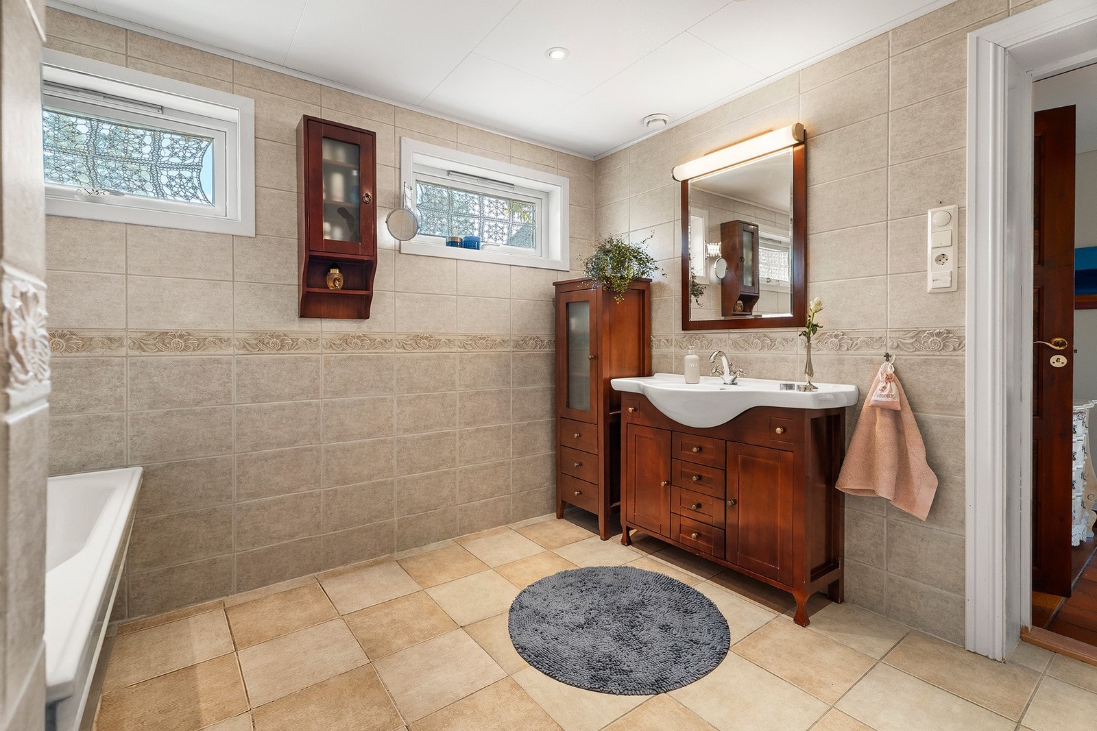 Rommet har flislagte gulv- og veggflater og elektriske varmekabler i gulvet. Galleribilde