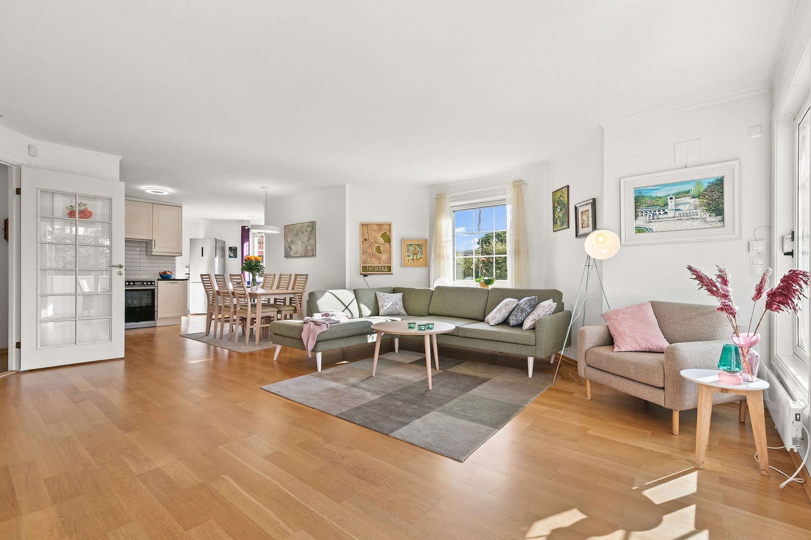 Romslig stue med lysinnfall fra flere vinkler. Her sett mot den åpne kjøkkenløsningen. Galleribilde