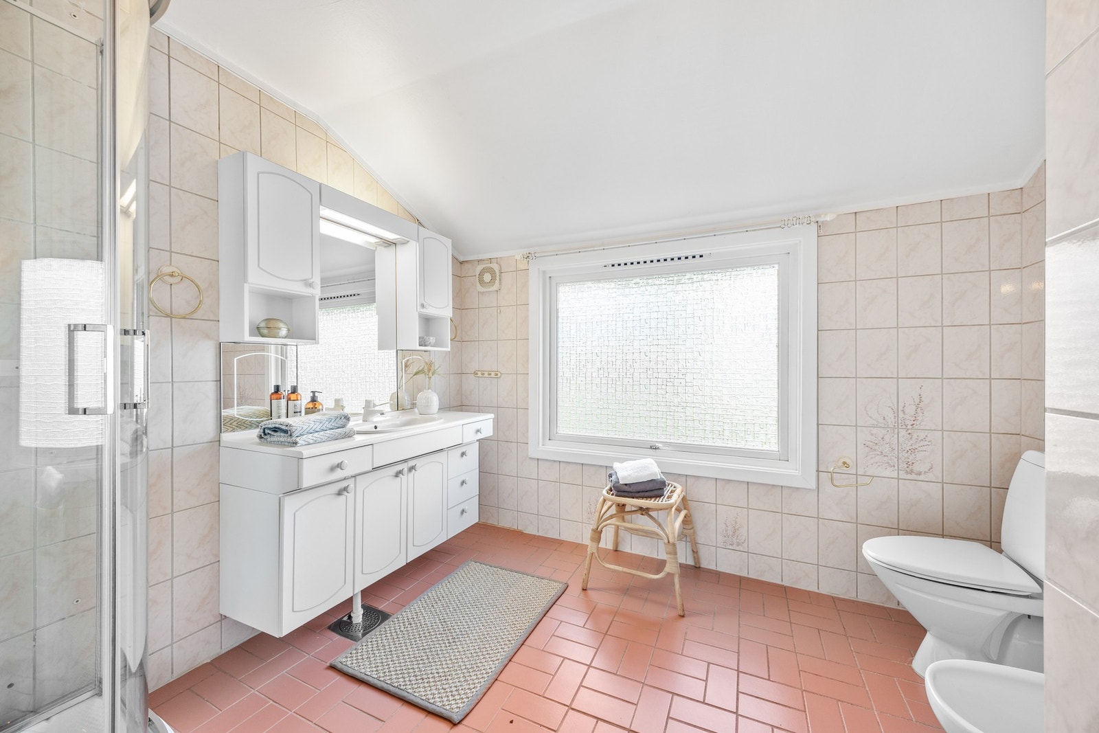 Badet har god størrelse og flislagte overflater Galleribilde