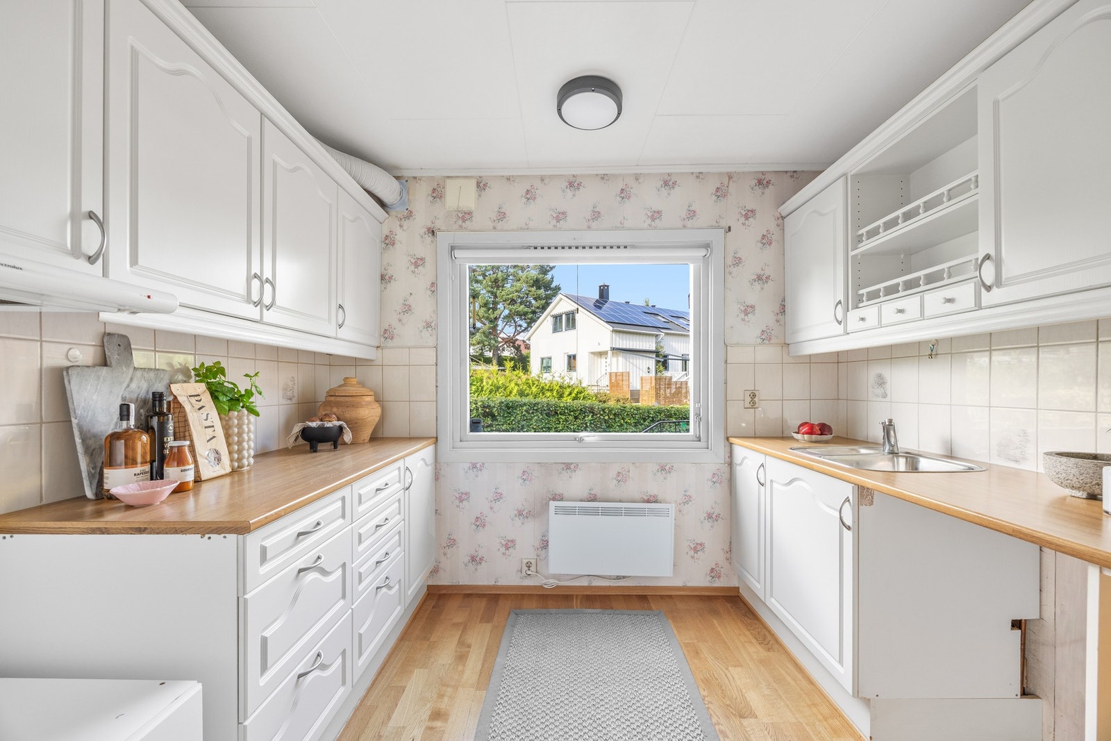 Kjøkkenet ligger i eget rom og har tradisjonell innredning langs to parallelle vegger Galleribilde