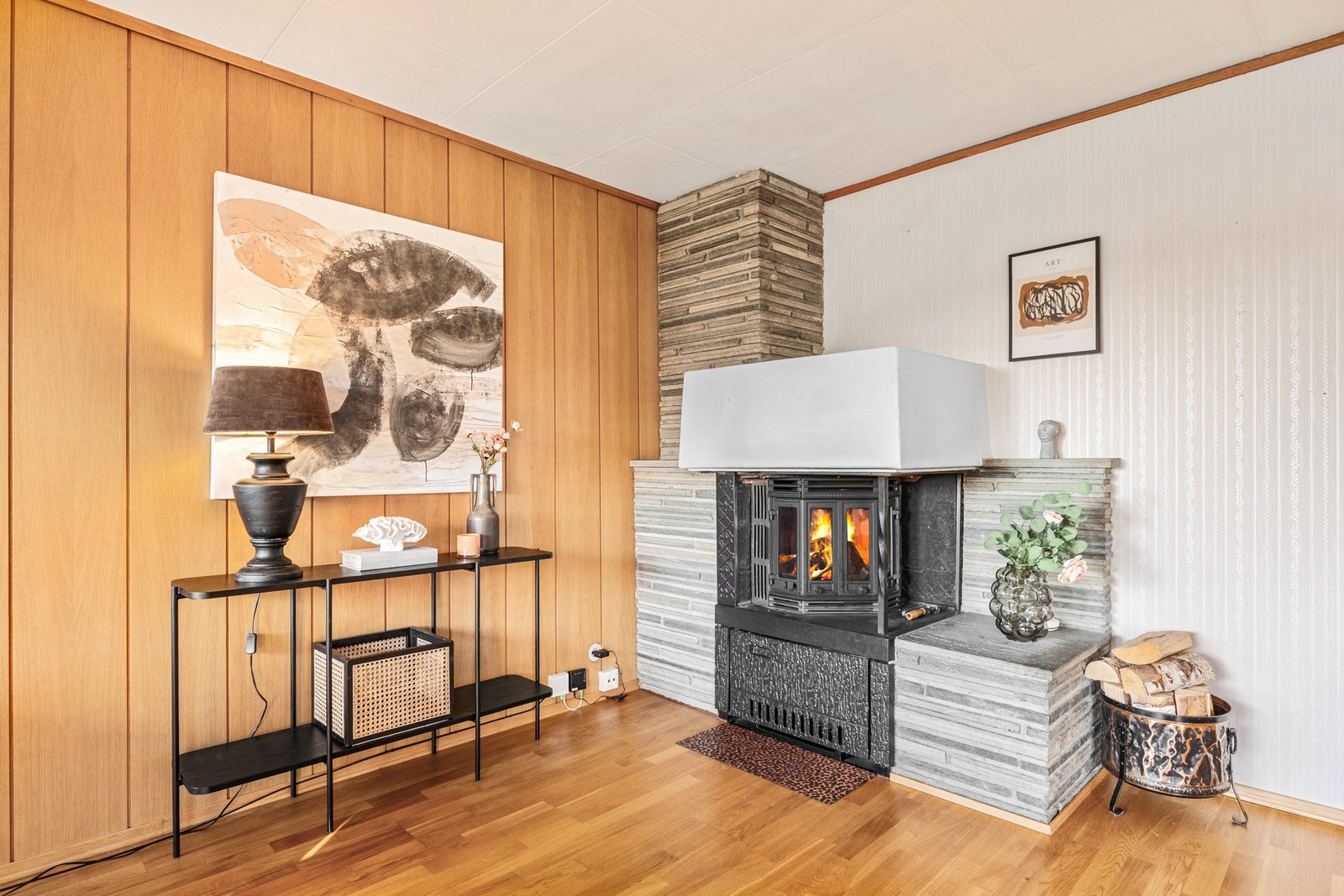 I det ene hjørnet i stuen er det peis med glassdør for vedfyring Galleribilde