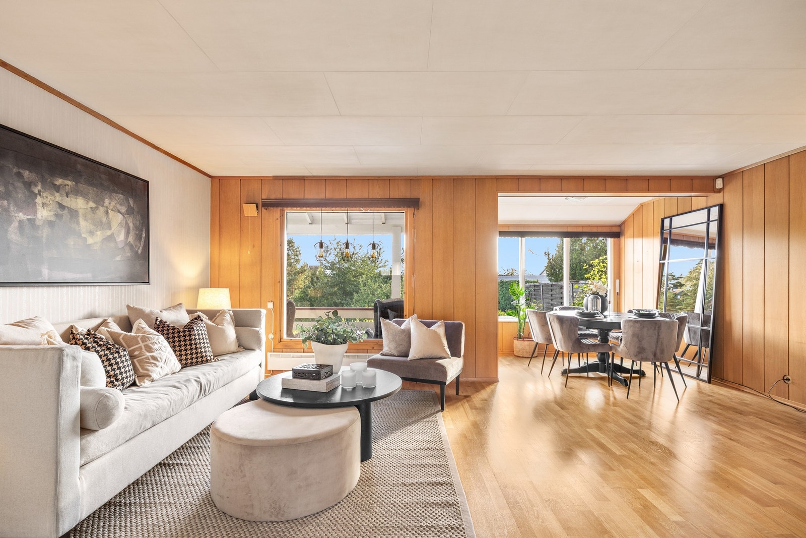 Boligen har en romslig stue med fint lysinnslipp fra store vinduer Galleribilde