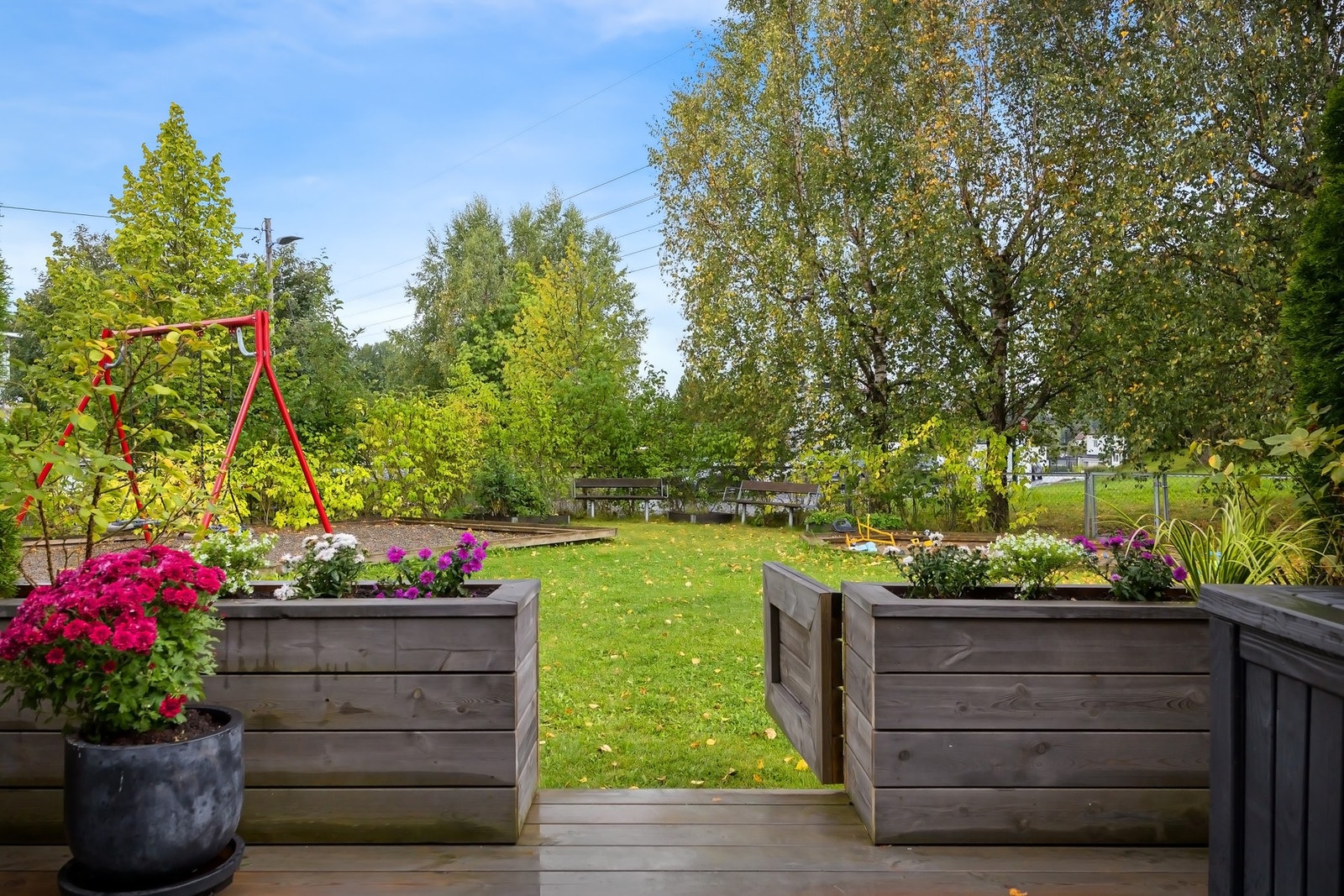 Solrik terrasse med direkte adkomst til fellesareal. Ny terrasse, port og blomsterkasser i 2022 Galleribilde