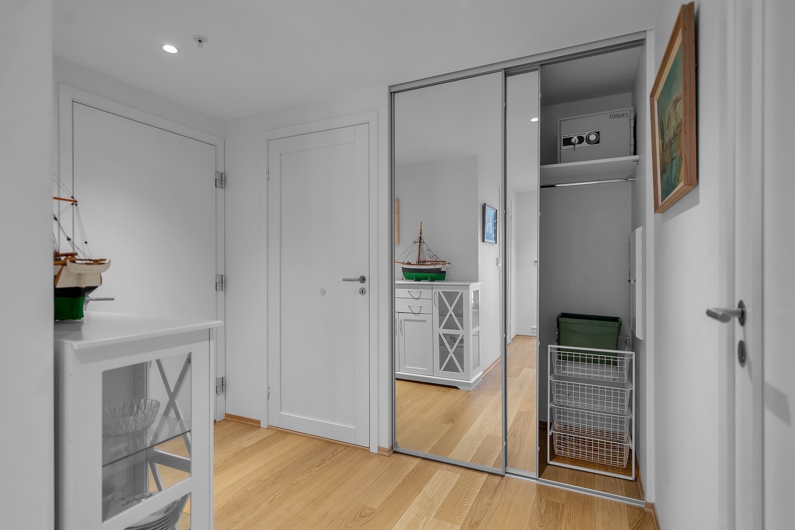 Her er det godt med plass til oppheng av yttertøy og sko, praktisk organisert i en romslig skyvedørsgarderobe med elegante speildører som både gir god oppbevaring og tilfører dybde til rommet. Galleribilde