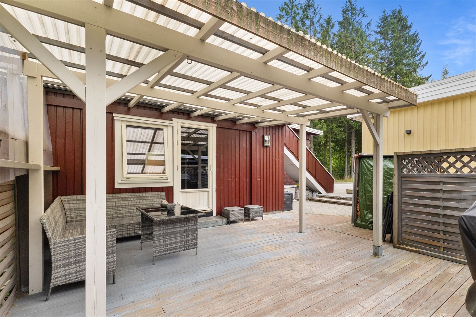 Fra ett av soverommene i 1. etasje er det direkte utgang til hagen, som byr på plen, beplantning og en romslig terrasse på ca. 45 kvm. Galleribilde