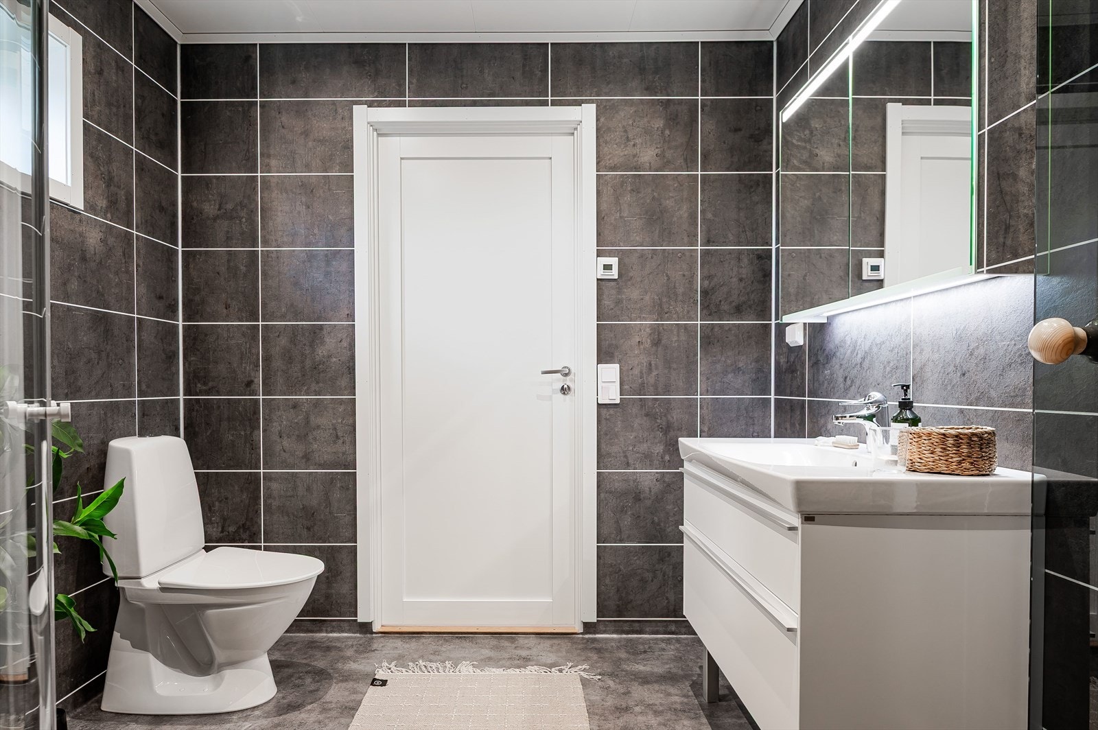 Hovedbaderommet er innredet med servant på innredning, toalett og dusjhjørne. Overskap med speil og belysning. Galleribilde