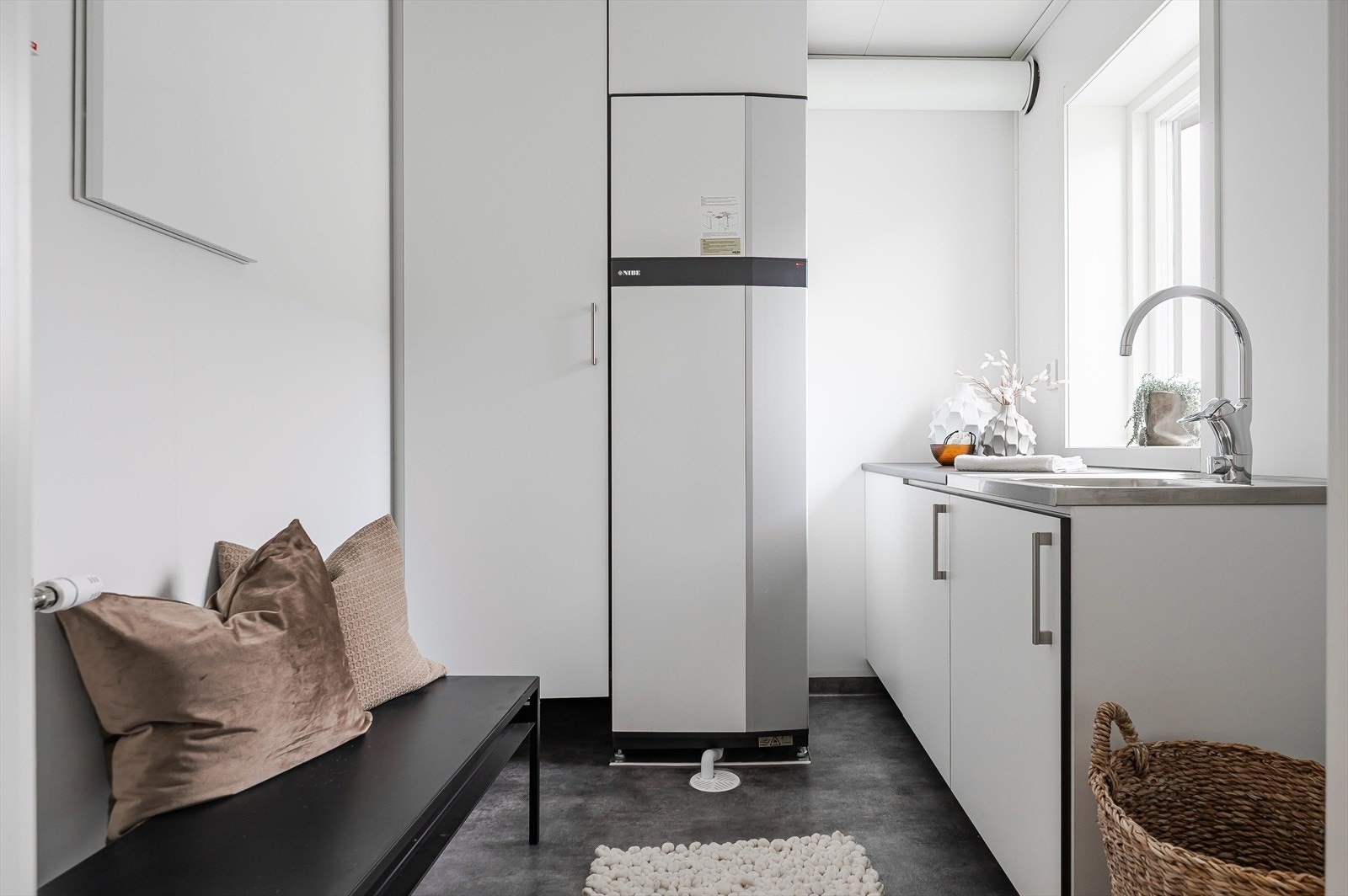 Praktisk separat vaskerom/teknisk rom med utslagskum og benkeskap. Galleribilde