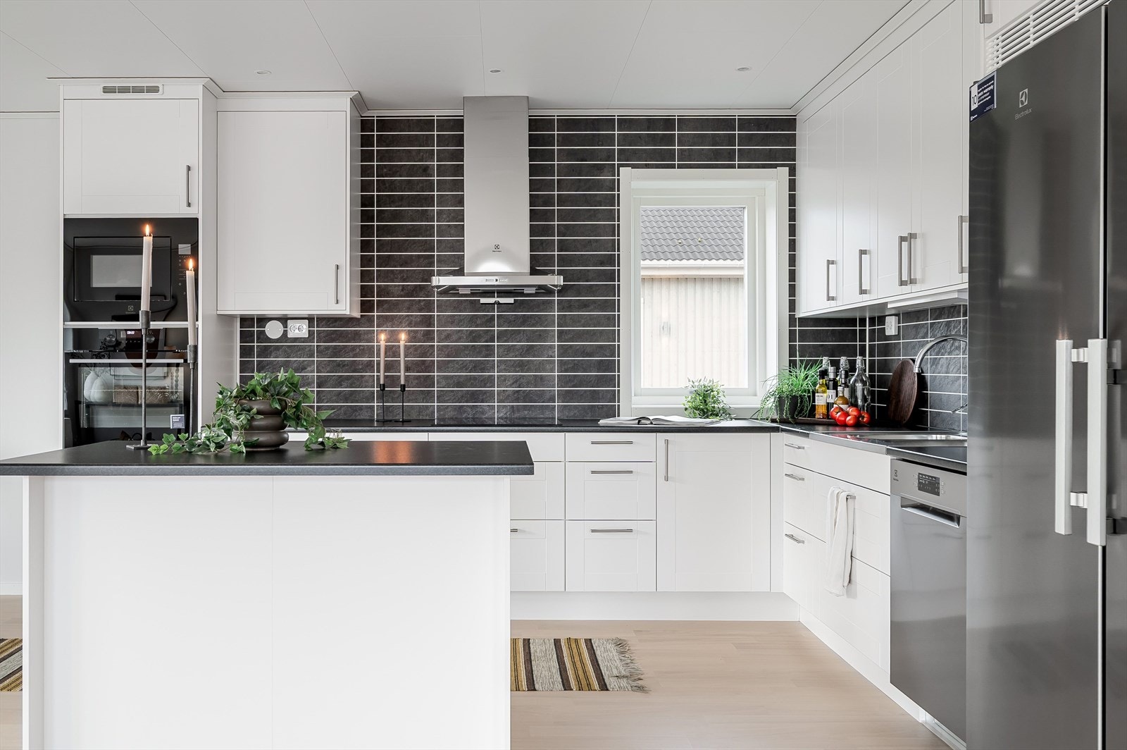 Innredningen har hvite profilerte fronter og laminert benkeplate med nedfelt oppvaskkum. Belysning under overskap. Galleribilde