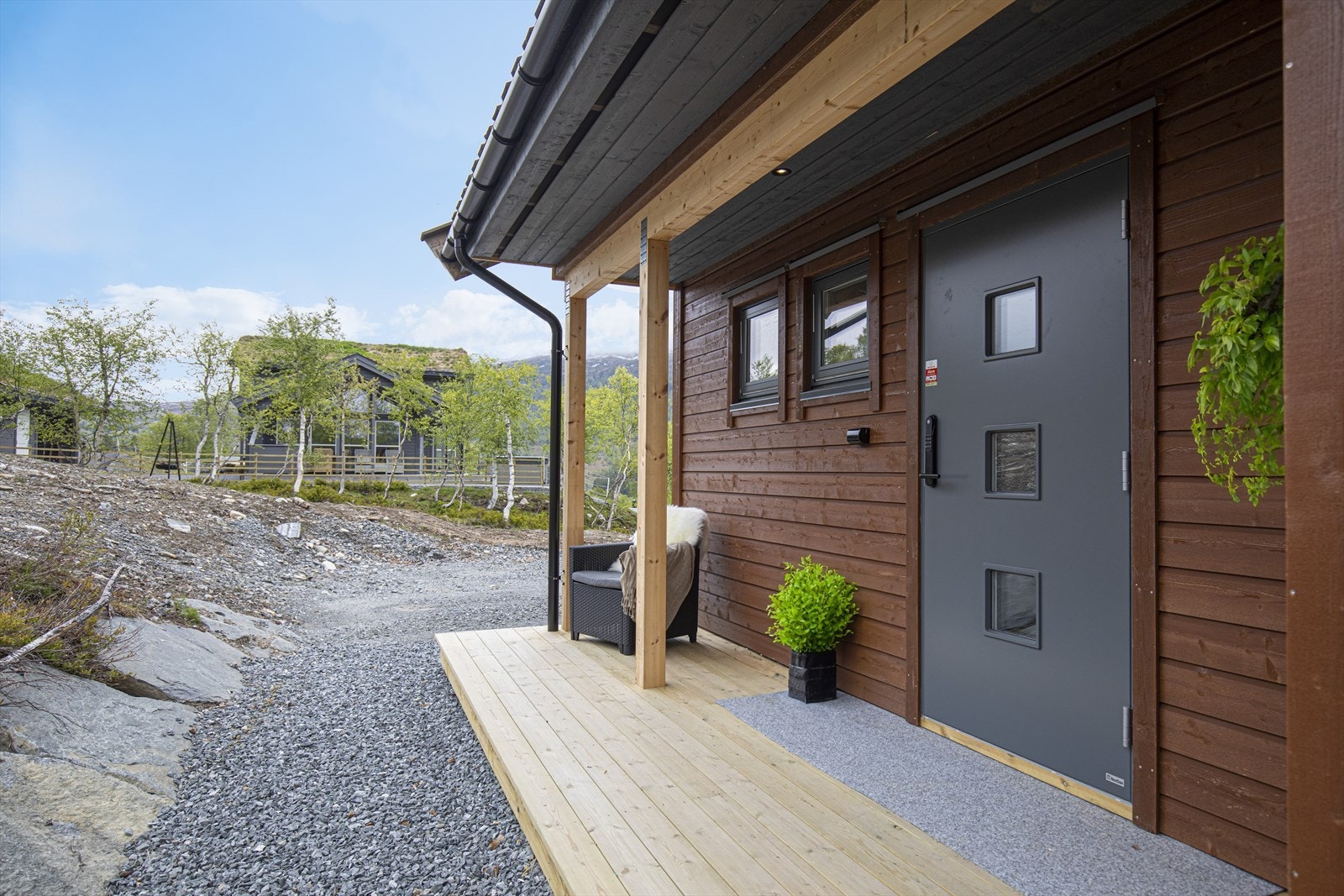 Overbygd inngangsparti med spotter i himling. Yale doorman og utvendig stikkontakt. Galleribilde