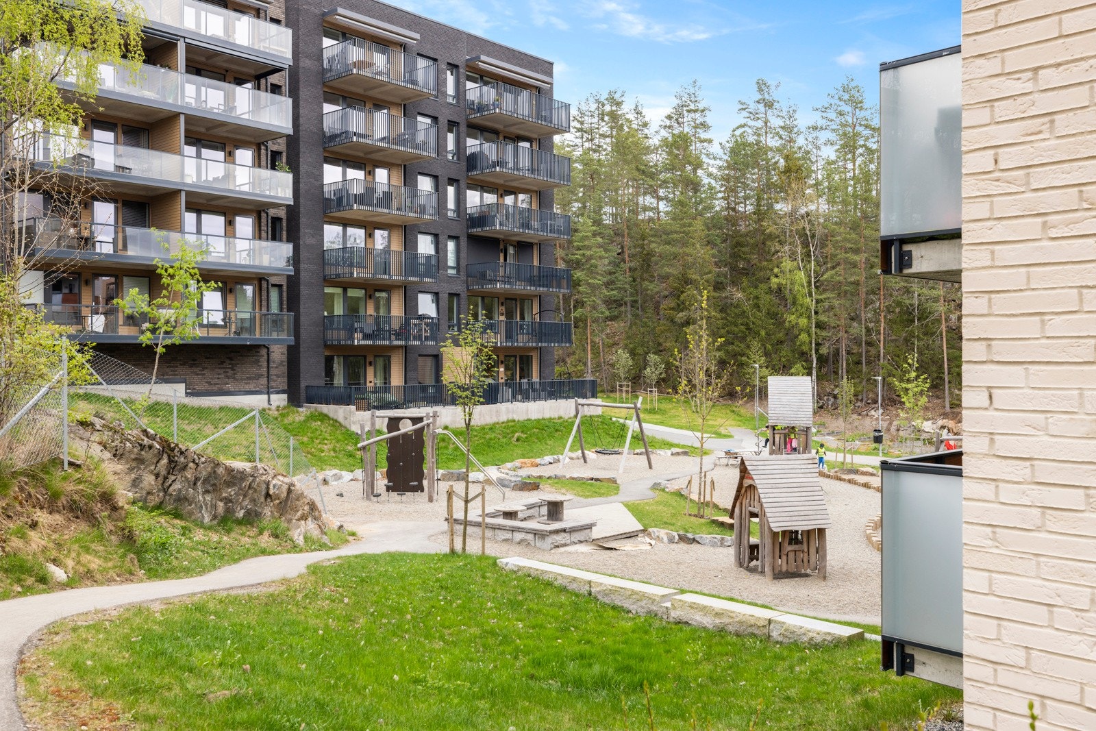 Pent opparbeidet felles gårdsrom med felles sittegrupper og lekeplass. Galleribilde