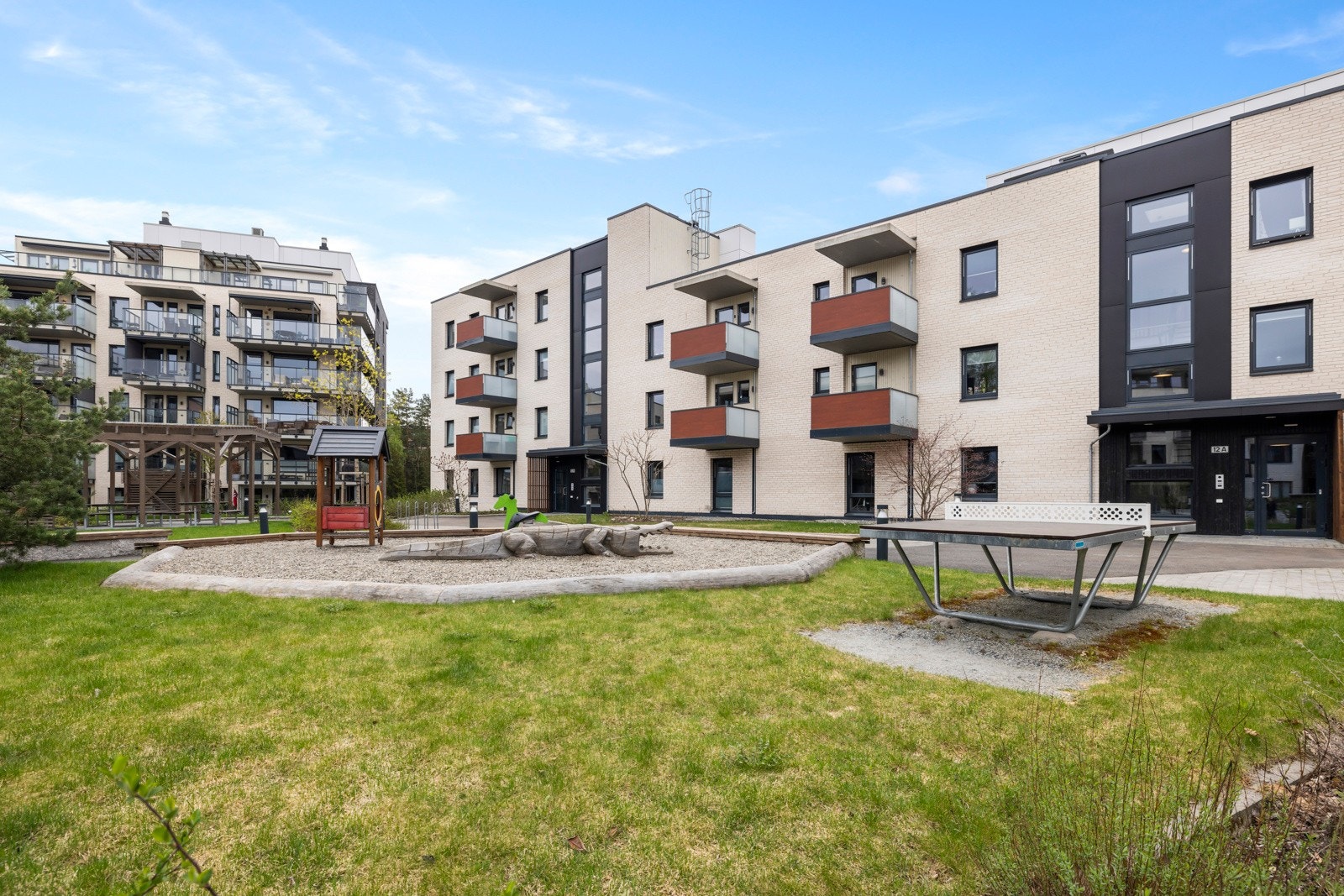 Pent opparbeidet felles gårdsrom med felles sittegrupper og lekeplass. Galleribilde