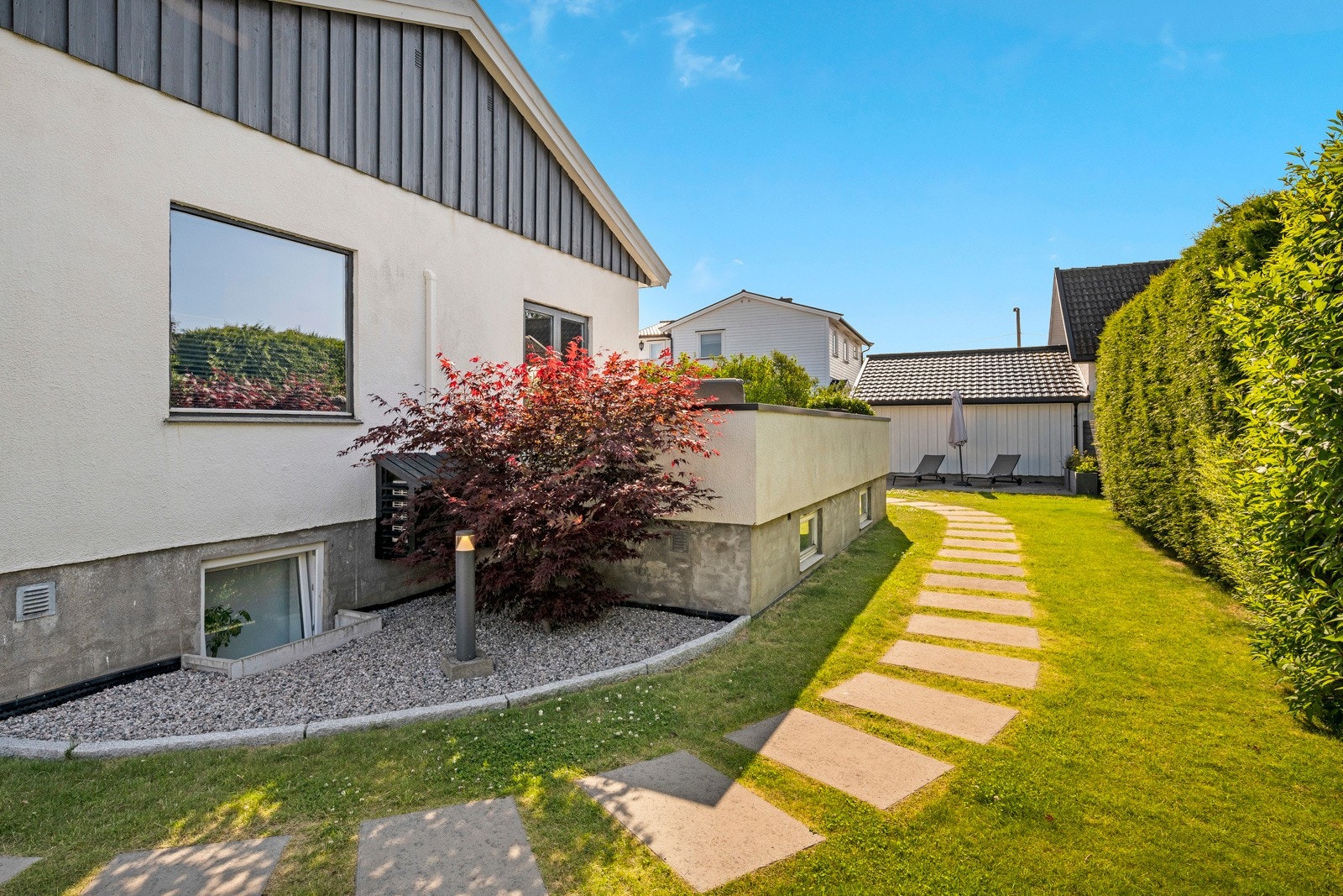 Hagen er pent opparbeidet med bade bedd, busker og plenareale. Hellelagt gangsti fra inngangsparti til hagen bak Galleribilde