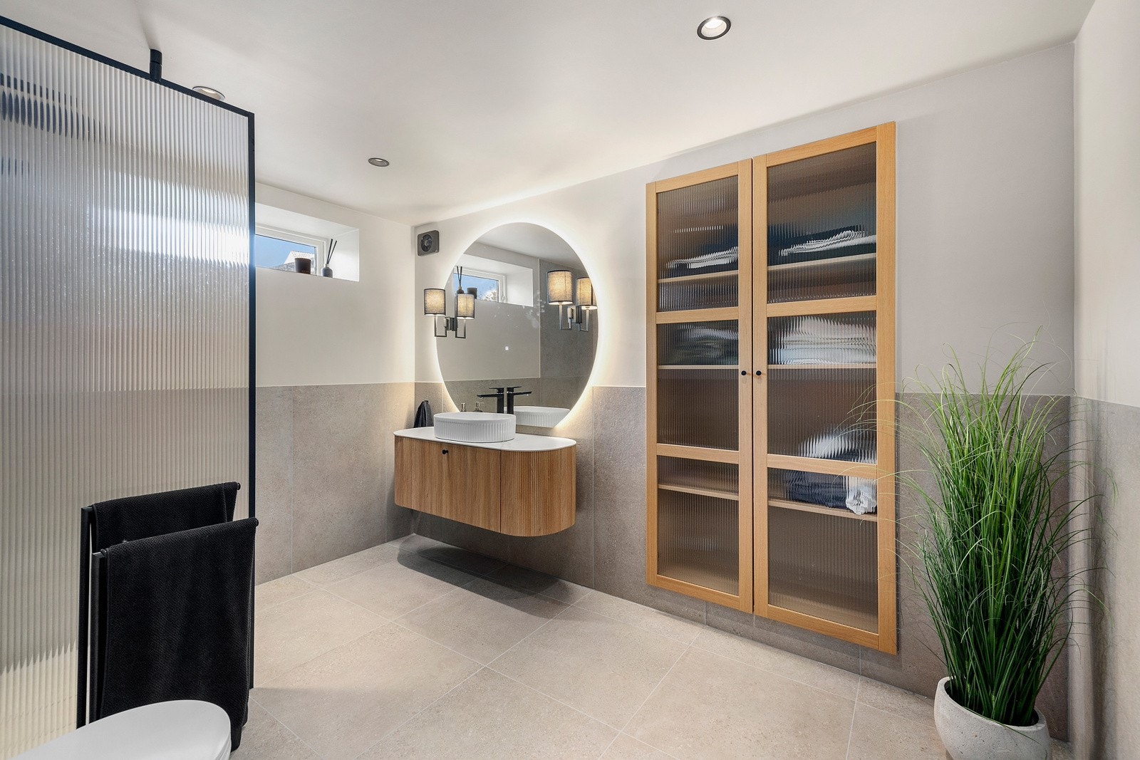 Det er dusjnisje, servant med innredning, speil med belysning og vegghengt toalett Galleribilde