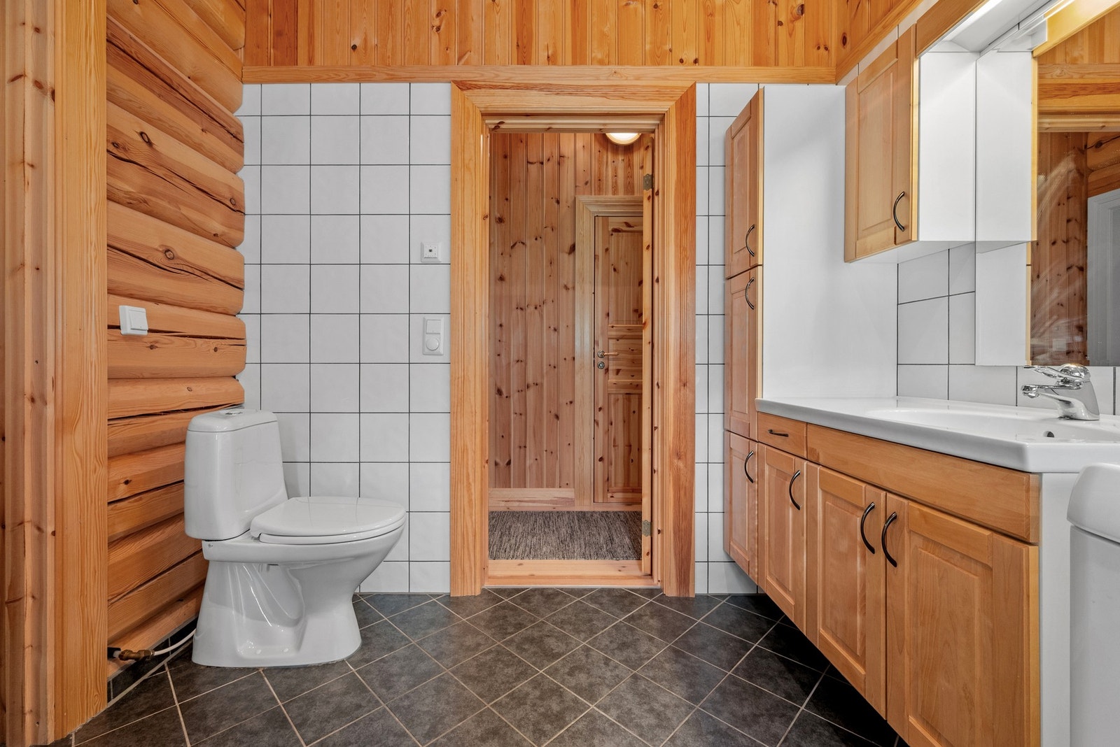 Badet er utstyrt med badekar, dusjkabinett, wc og servant i innredning. Galleribilde